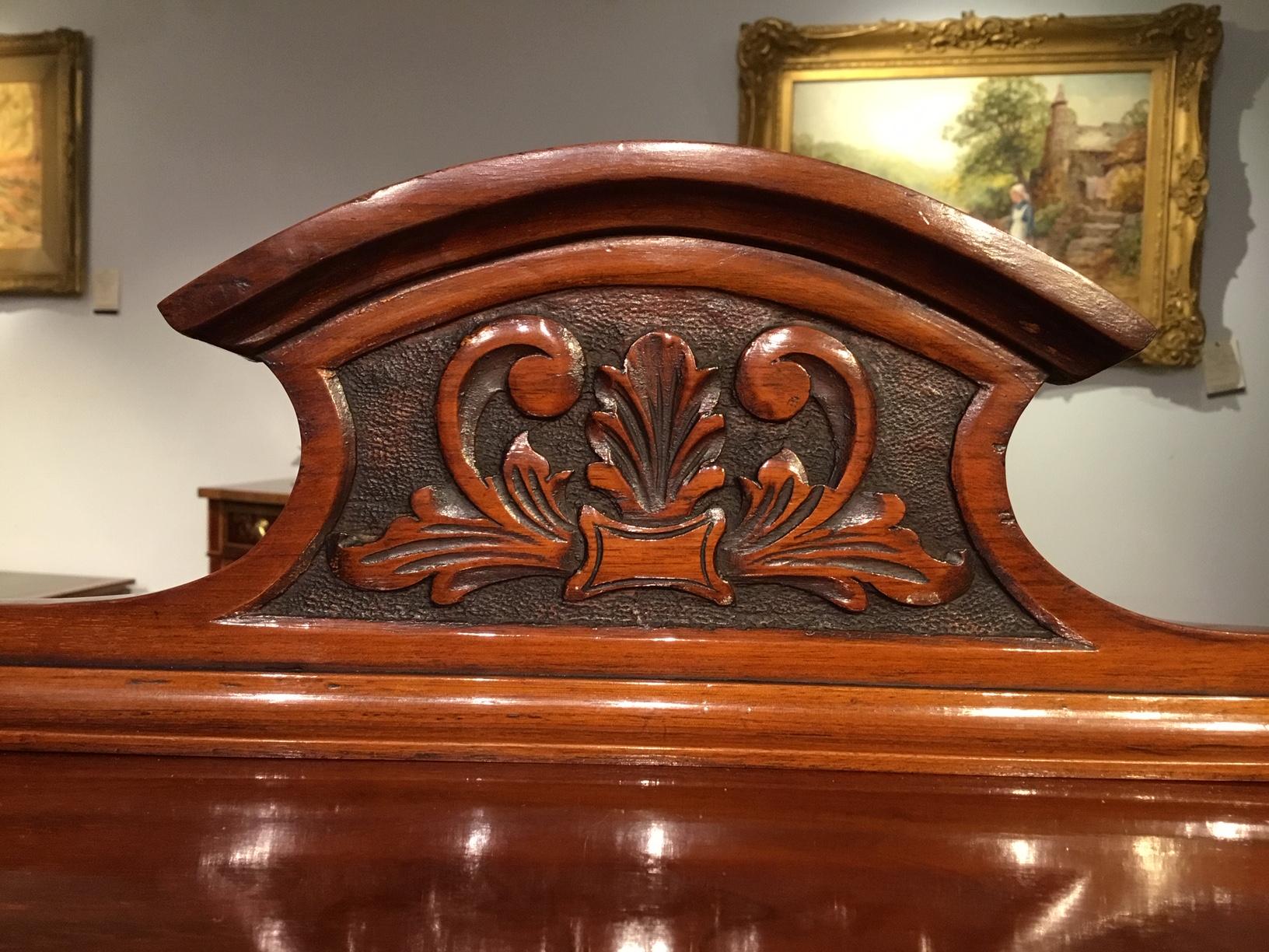 A walnut late Victorian period music cabinet. Having a carved galleried back above a serpentine shaped shelf with a mirrored back. Having two drop down compartments with velvet lined shelves for sheet music. The lower section having a nicely carved