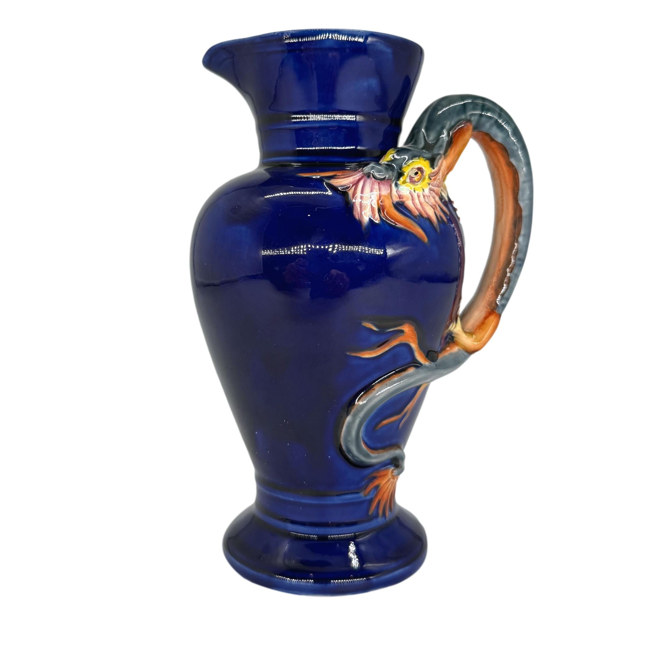 Drachenkrug aus Majolika, entworfen von Hugues Protât (Franzose, 1835-1871) für Wedgwood. Der eiförmige Krug ist kobaltblau glasiert mit einem hell glasierten Drachen, der den Henkel bildet, das Innere ist türkis glasiert, die Rückseite trägt die