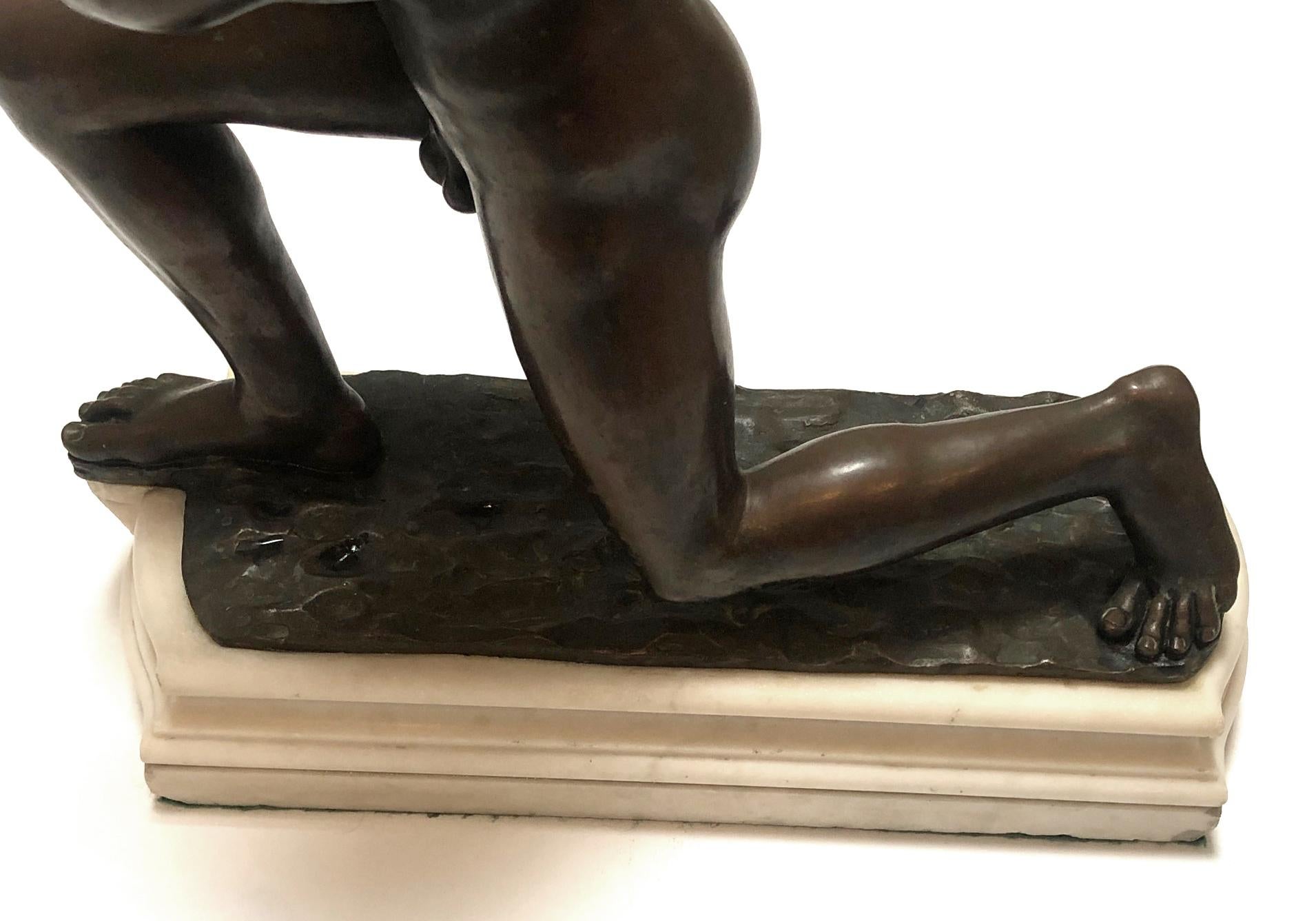 The muscular kneeling figure with arm outstretched; the whole resting on a shaped marble plinth.