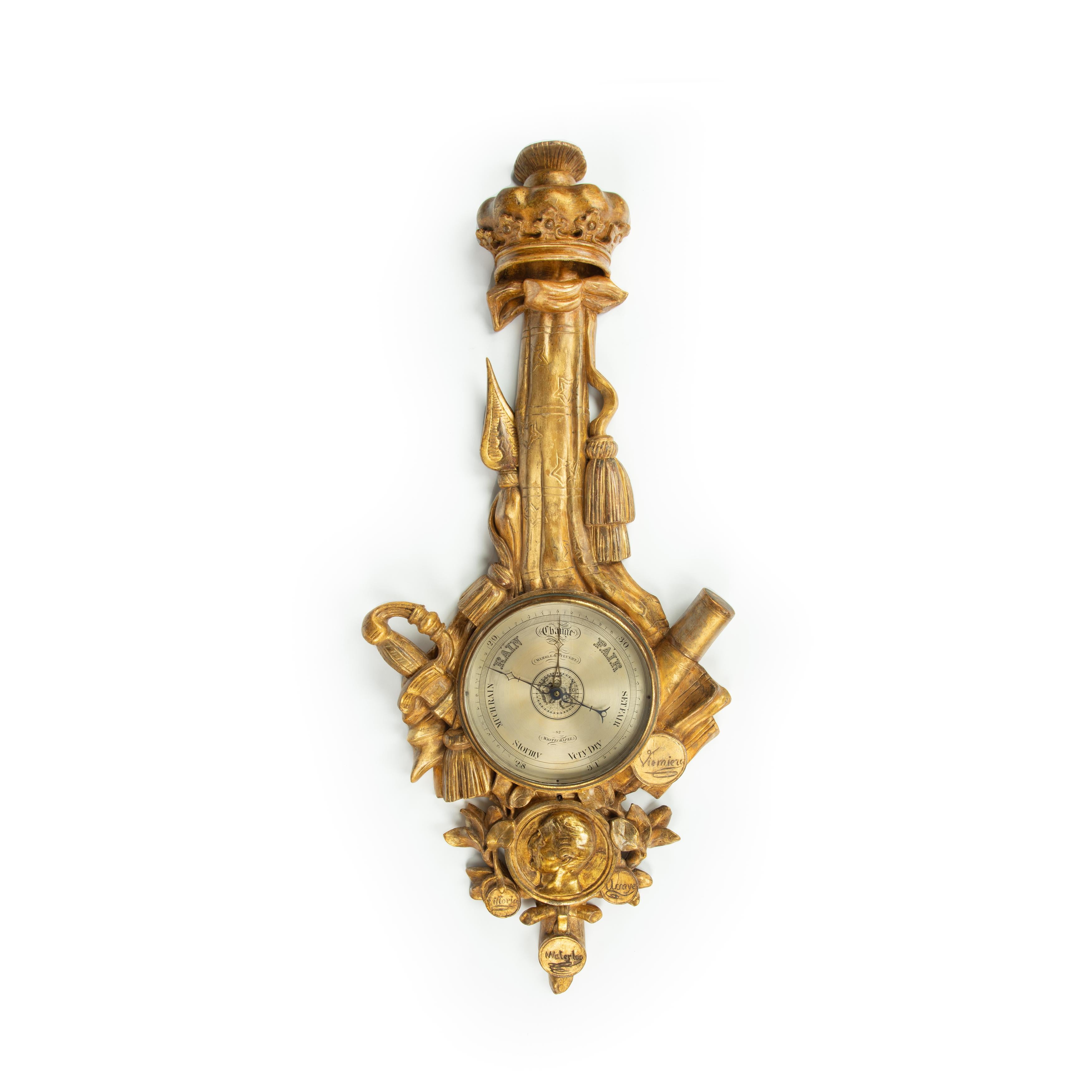 This carved giltwood barometer is in the form of a military trophy of arms surmounted by a ducal coronet.  It comprises a sword hilt, cannon barrels and standards surrounding a portrait medallion of Arthur, 1st Duke of Wellington, in profile, and