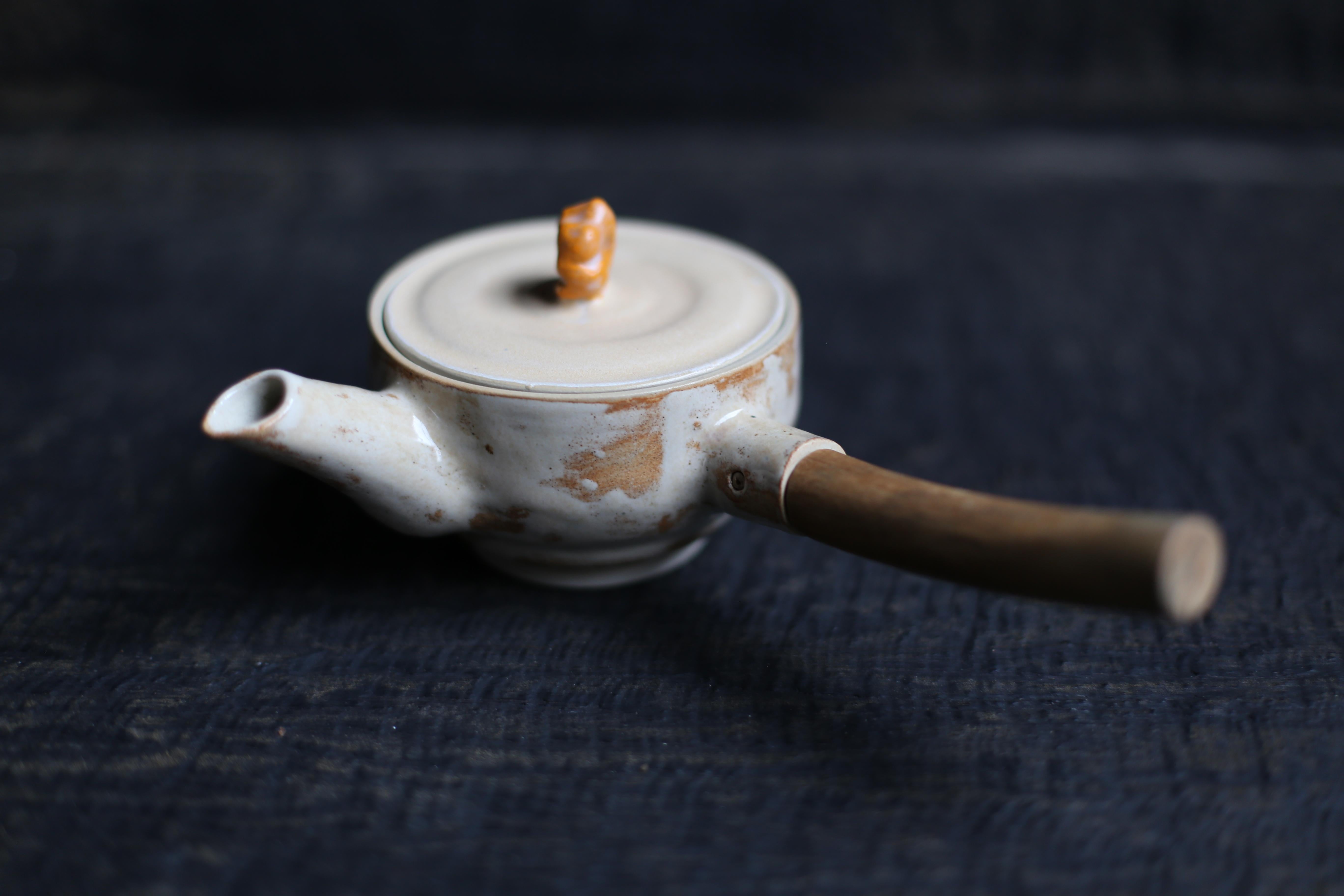 A wheel thrown Teapot with a branch handle (joinery) in White Clay with Cream
2022s / Belgium
Size : W 235, D 110, H 90 mm.
Artist : Sigrid Volders


[Sigrid Volders]
Based in Antwerp, Belgium, she works vigorously as a ceramic artist, mainly