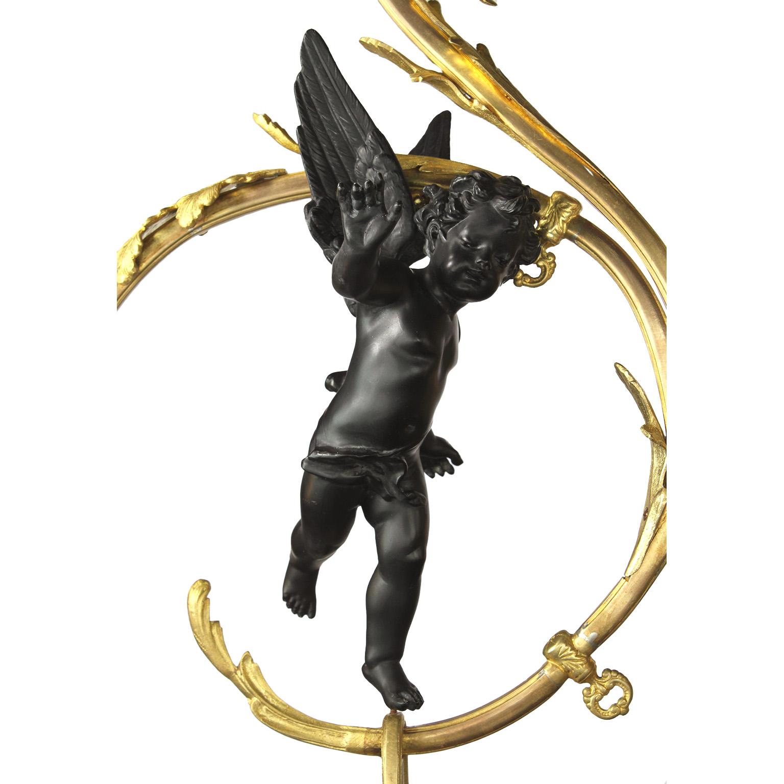 A fine whimsical French Belle Époque gilt and ebonized bronze cherub four-light gasolier pendant chandelier. The scrolled acanthus gilt-bronze frame, with its original gas key-valves surmounted with four frosted glass floral shades and centered with