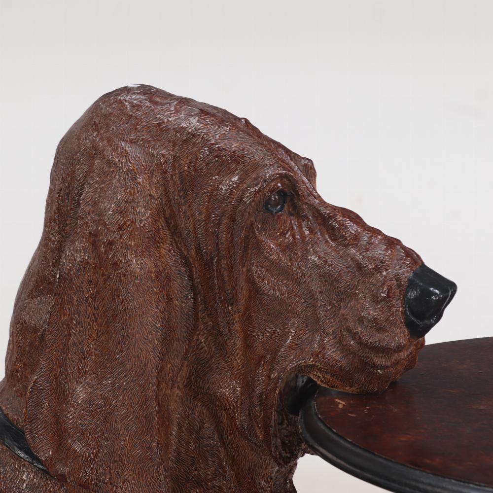 Cette adorable table représente un chien Basset Hound assis et tenant un plateau rond, attendant de vous servir. Un endroit parfait pour votre cocktail du soir, assis près d'un feu chaleureux ou près de la porte d'entrée comme zone de dépôt pour vos