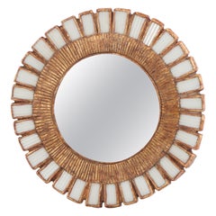 Uno specchio bianco in vetro e resina in stile "sunburst".