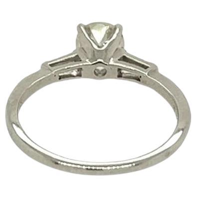 A 14 karat white gold and diamond ring.  Centering a brilliant cut diamond weighing 0.75 carat* highlighted by two (2) tapered baguettes.  Total diamond weight approximately 0.85 carat.  Size approximately 5 3/4.  Gross weight approximately 1.90