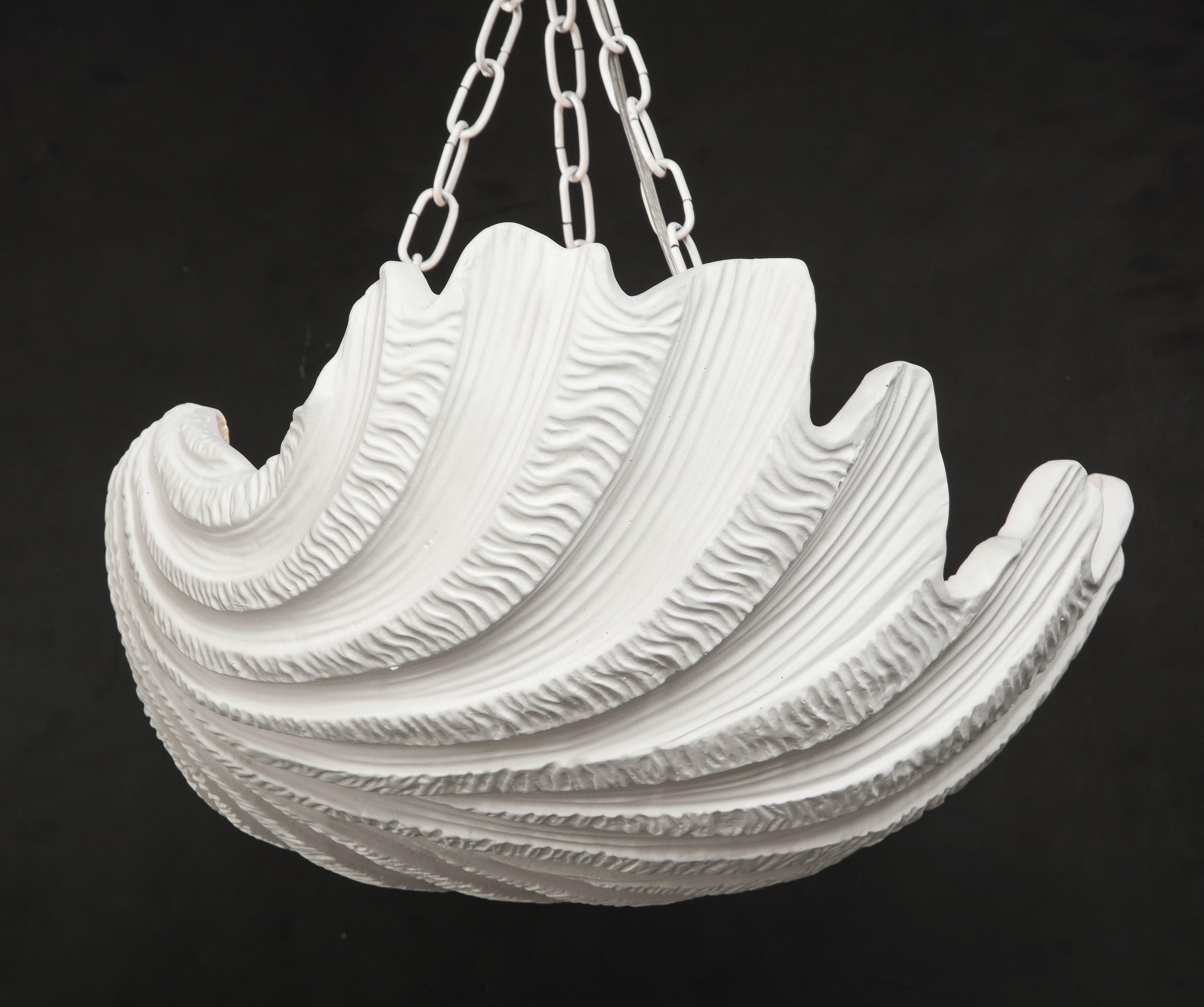 A striking asymmetrical scalloped chandelier in white fiberglass resin by Sirmos with scalloped edges and ribbed textures with three newly wired sockets for standard bulbs for the U.S. market and refinished painted surface attached to chain at three