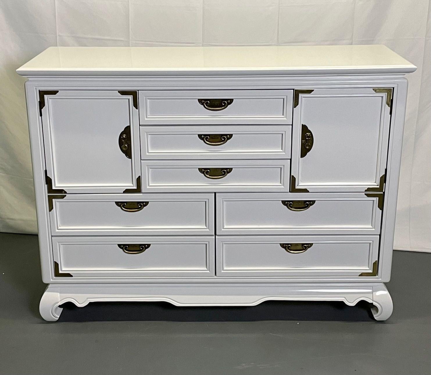 A White Lacquered Campaign Style Chest, Cabinet or Mini Armiore
A chest or cabinet of campaign style done over in the Hollywood Regency Style having a fine white lacquered finish. A pair of large storage doors flanking three drawers over two by two