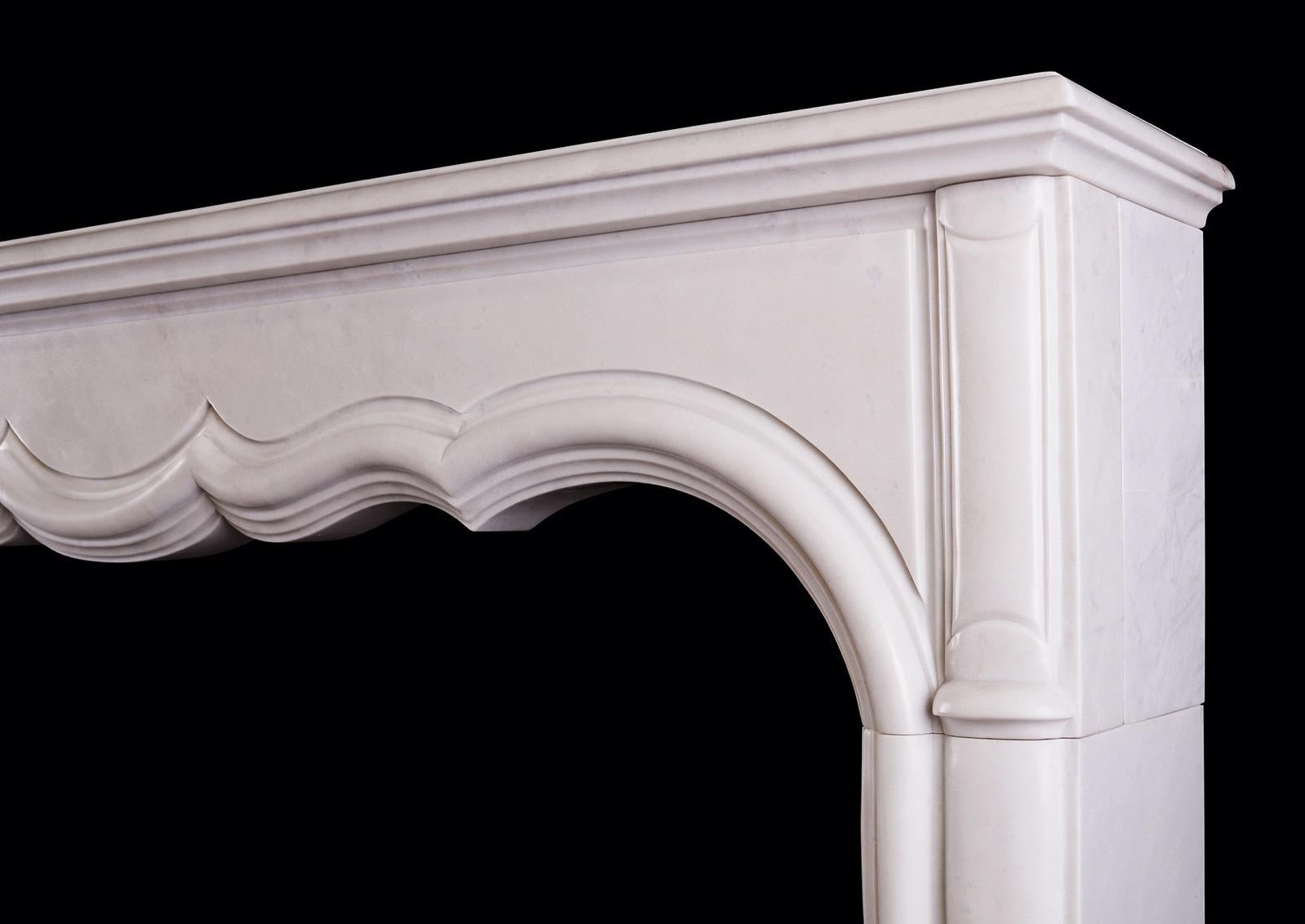 A white marble fireplace in the transitional French LXIV / LXV style. The shaped, panelled frieze with heavy inner moulding and elegant, shaped jambs below. Moulded shelf above. Mid to late 20th century.

Measures: Shelf width: 1678 mm 66