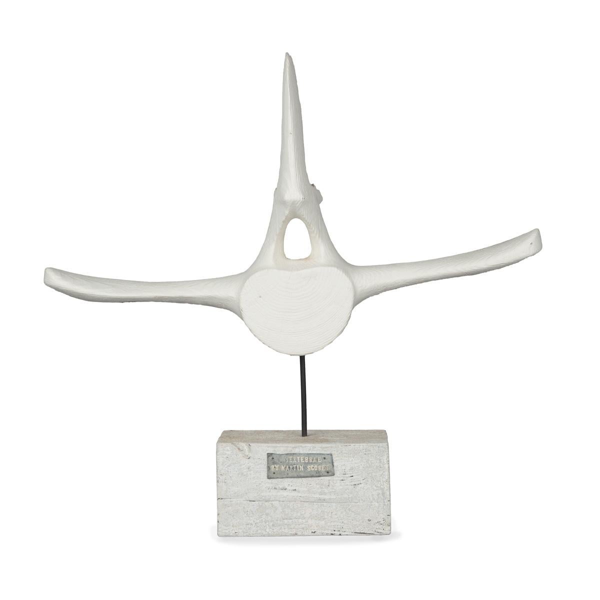 A white painted driftwood whale vertebra by Martin Scorey, set on a painted wooden block with a metal label stating ‘Whale vertebrae by Martin Scorey’. English, circa 2010.

