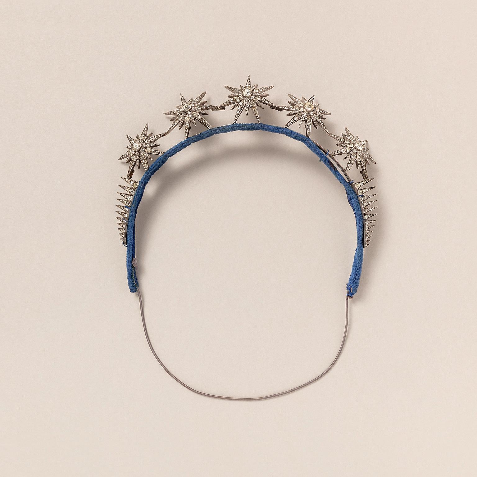 A tiara with five paste stars set on a a metal headband, inligned with blue velvet. On both sides are twelve radiating combs, descending in size. Provenance: The Late Lady Chalfont, of The Granary, Dean Manor Chipping Norton, Oxfordshire, England,