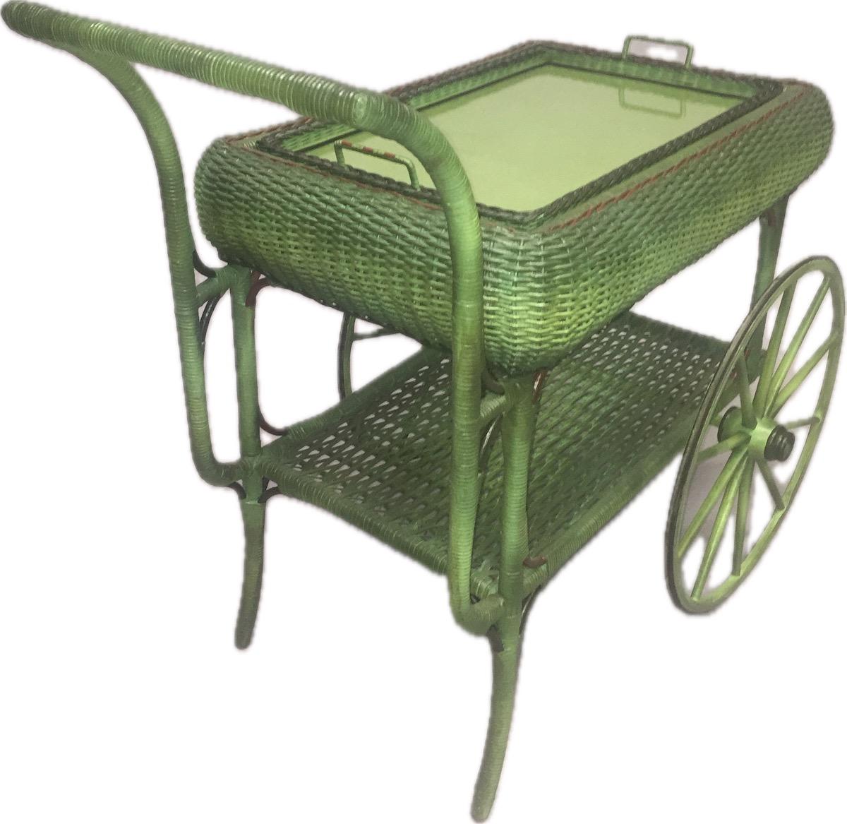 A rare rolled skirted serving cart in French green finish with red and black accented trim, American, Heywood Wakefield Company,Gardner,Ma.This piece is elegantly designed with large oversized rubberized wheels, a convenient large woven bottom