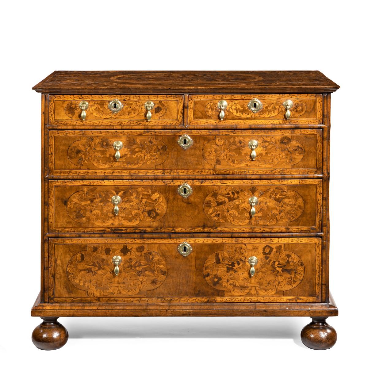 A William and Mary marquetry walnut veneered chest of drawers, of rectangular form with two short and three graduated long drawers, the top decorated with an oval of fleshy acanthus leaves and sprays of flowers in a variety of woods, with further