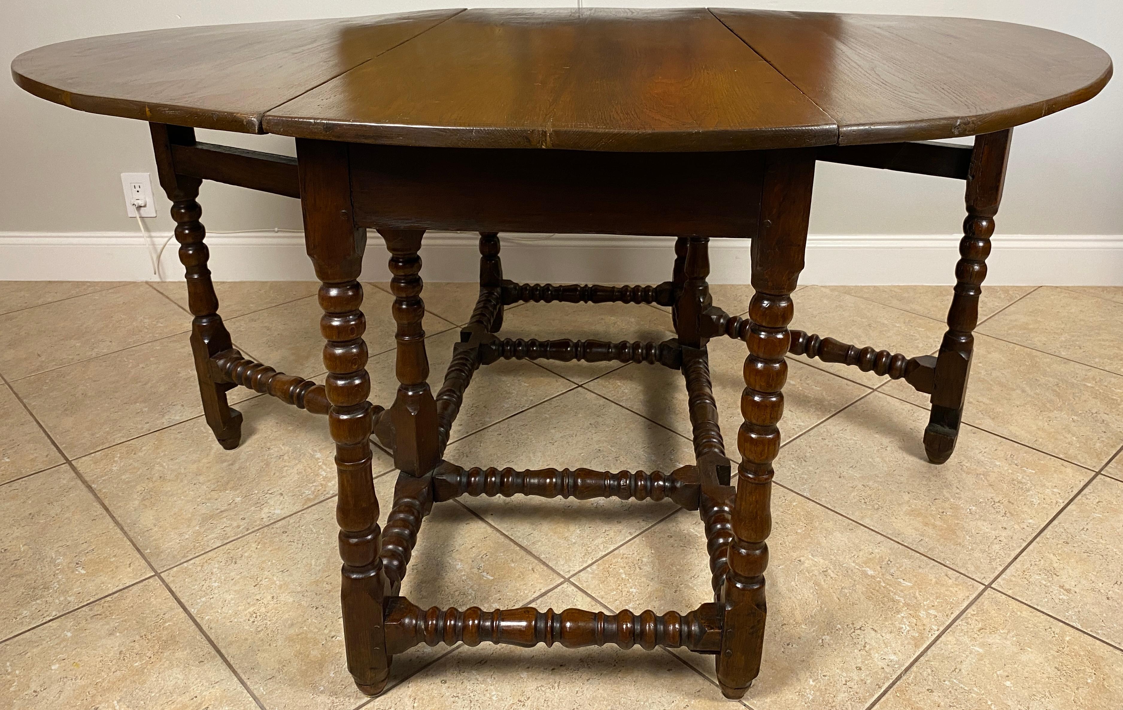 Exquisite 17th–18th Century William and Mary Oak Gateleg Table or 
Antique English Extendable Oval Drop-Leaf Dining Table

An exceptional late 17th to early 18th century English William and Mary oak gateleg table, showcasing the fine craftsmanship