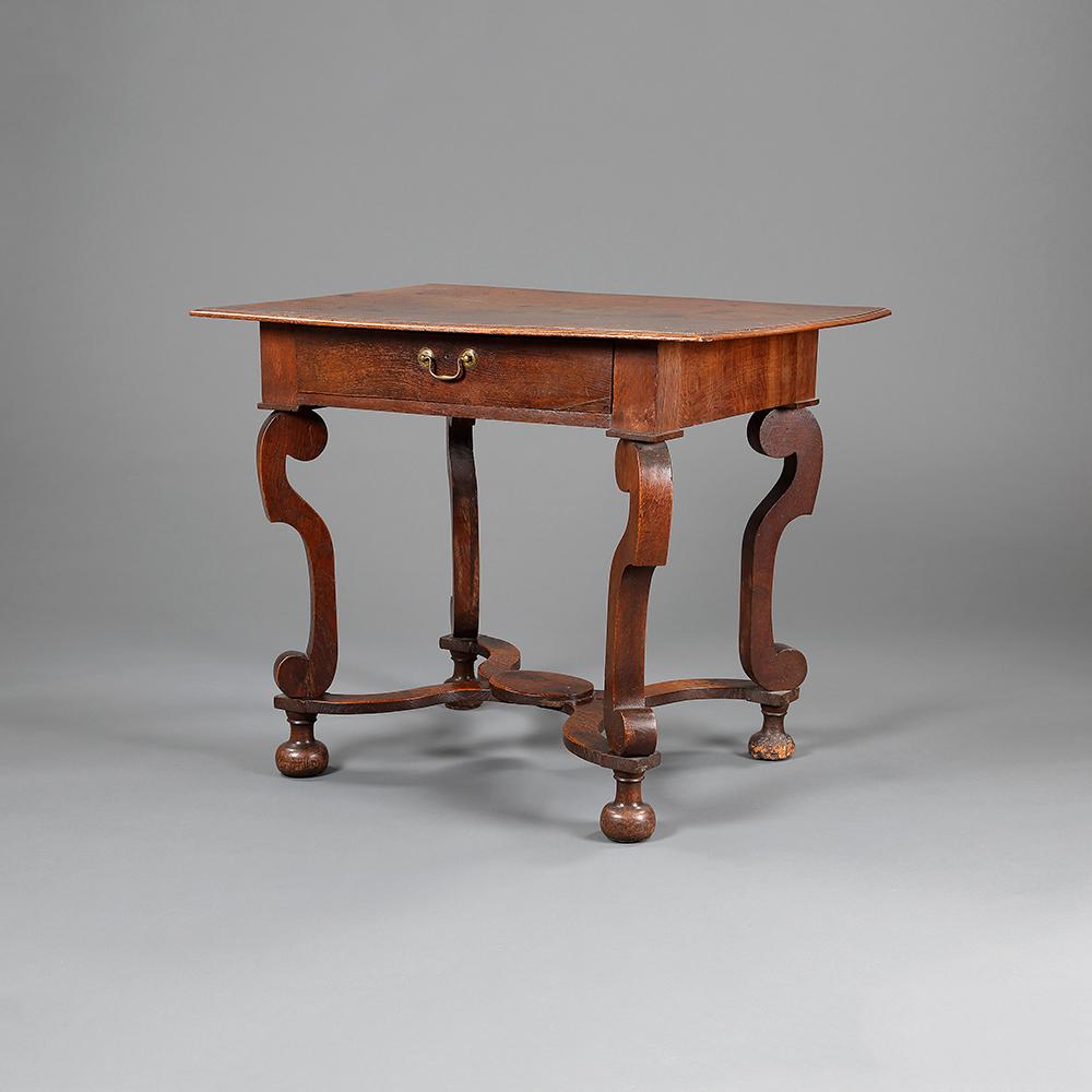 A William and Mary oak side table, possibly incorporating earlier elements, having a single drawer, raised on scrolled legs.