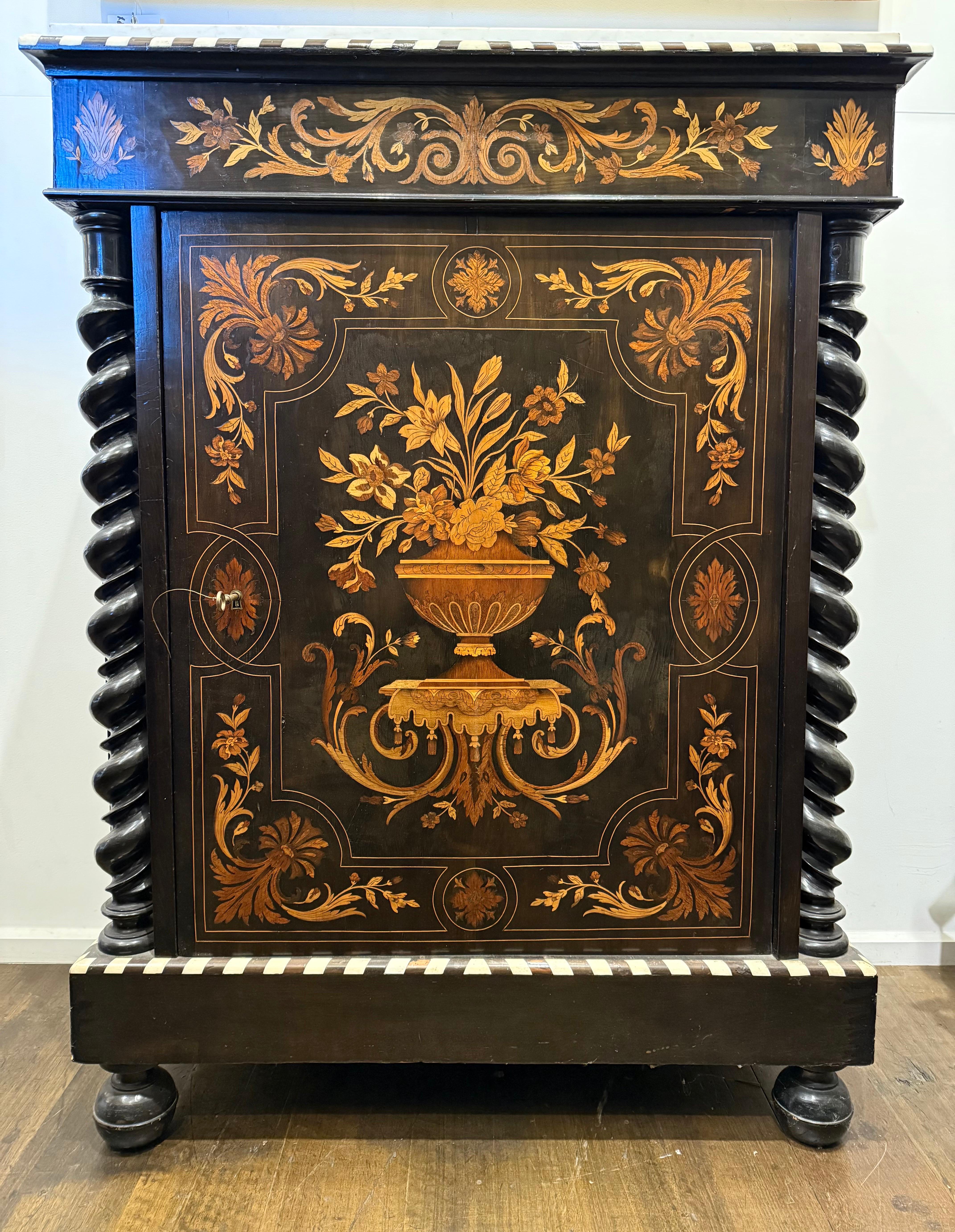 Armario de marquetería y tapa de mármol estilo William & Mary, S. XIX

Descripción:
La encimera rectangular de mármol blanco está enmarcada por un borde moldurado en óvalo de hueso y madera ebonizada, sobre un friso con incrustaciones centrales de