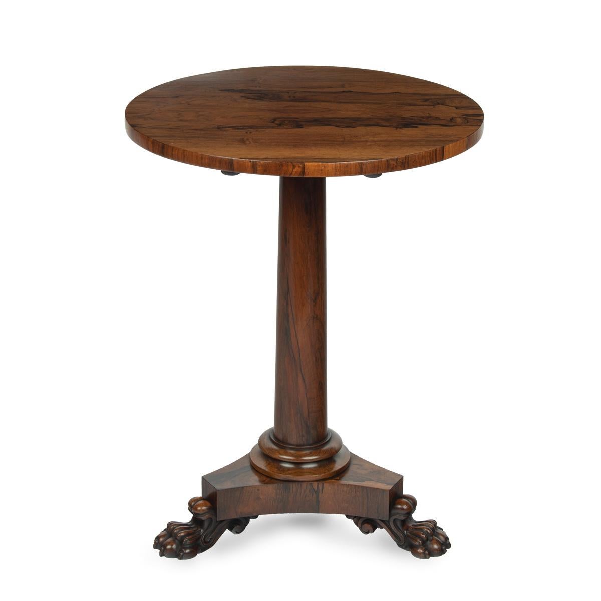 A William IV circular occasional tilt-top table, the figured rosewood top raised on a tapered column, the tripod base with three powerful lion’s paw feet.  English, circa 1830.

