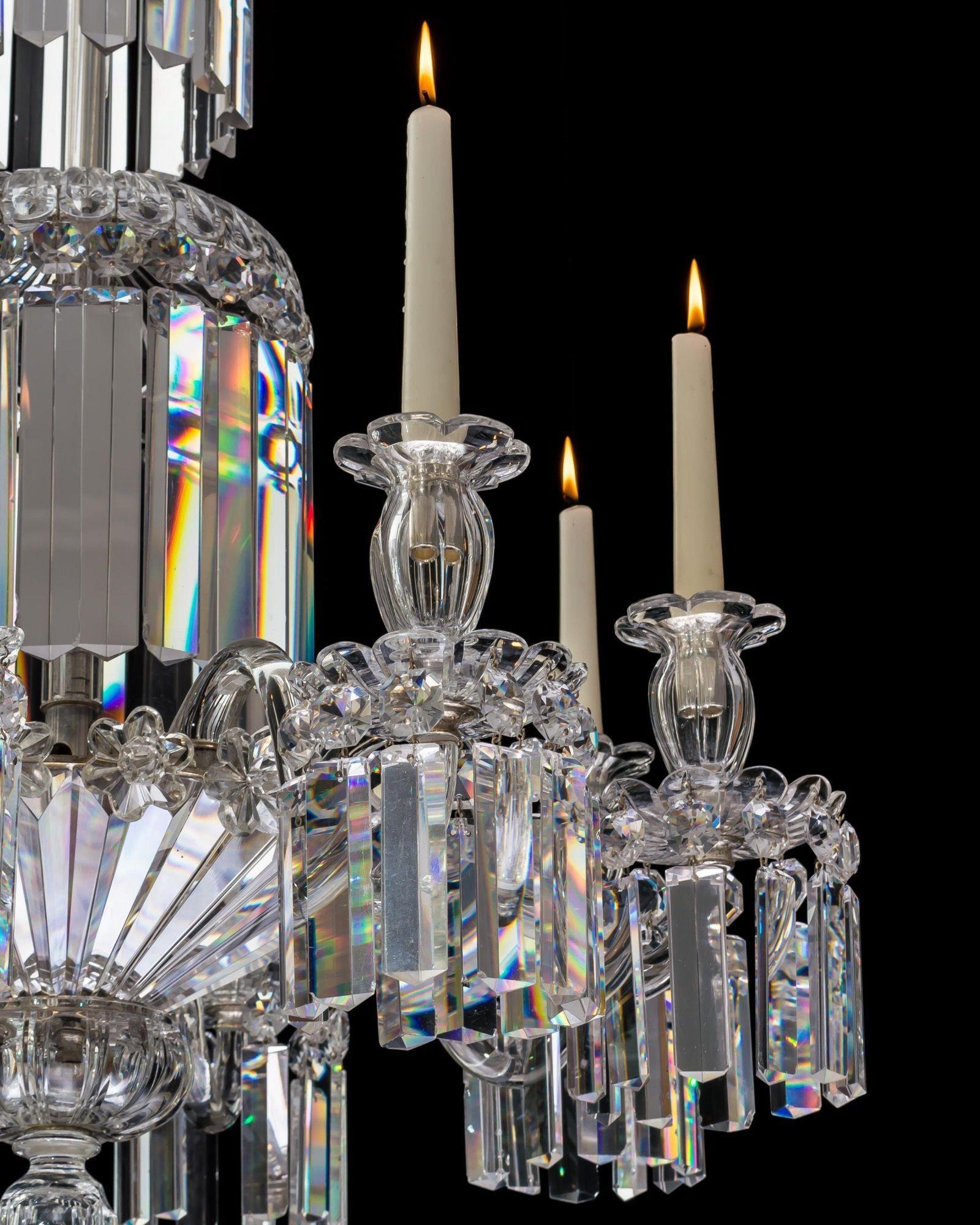 A fine quality silver mounted chandelier, the stem with graduated drop hung dishes cascading down to the main frame, issuing eight plain arms supporting drop hung scalloped edge drip pans and candle nozzles, the frame incased underneath with