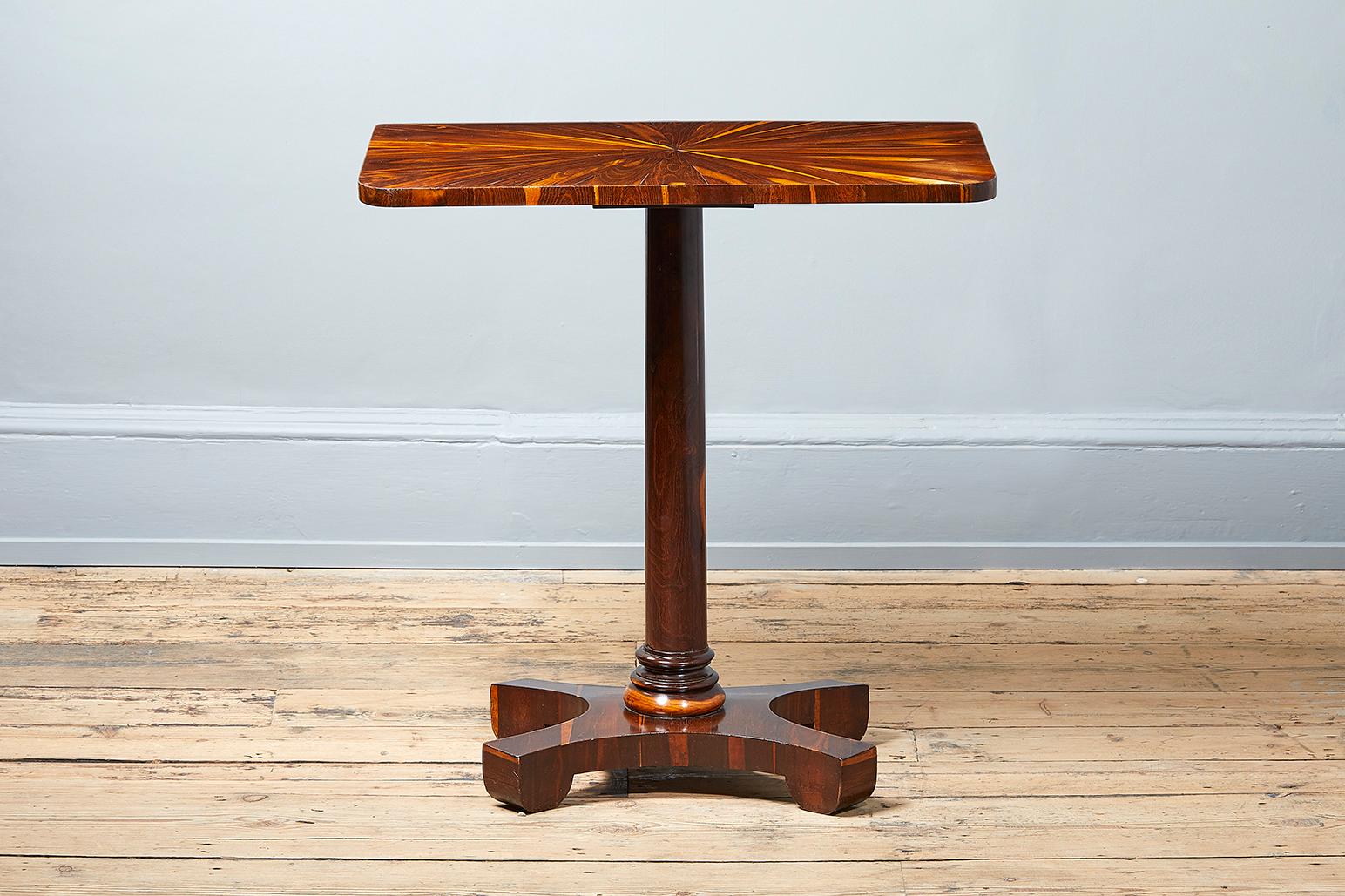 A William IV laburnum occasional table, circa 1830, rectangular top with rounded corners veneered in a radiating pattern, on a tapered column with ring turned socle and a quadripartite base, with shaped feet.