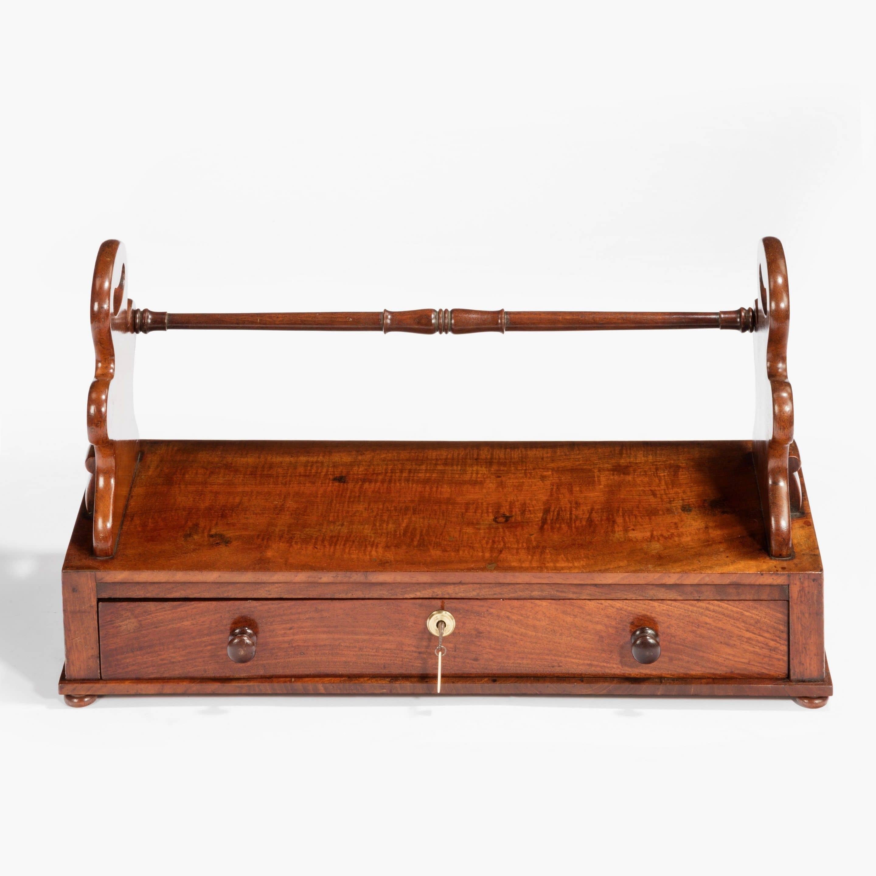 A William IV mahogany book carrier the shaped ends with openwork handles, the frieze with a single drawer.