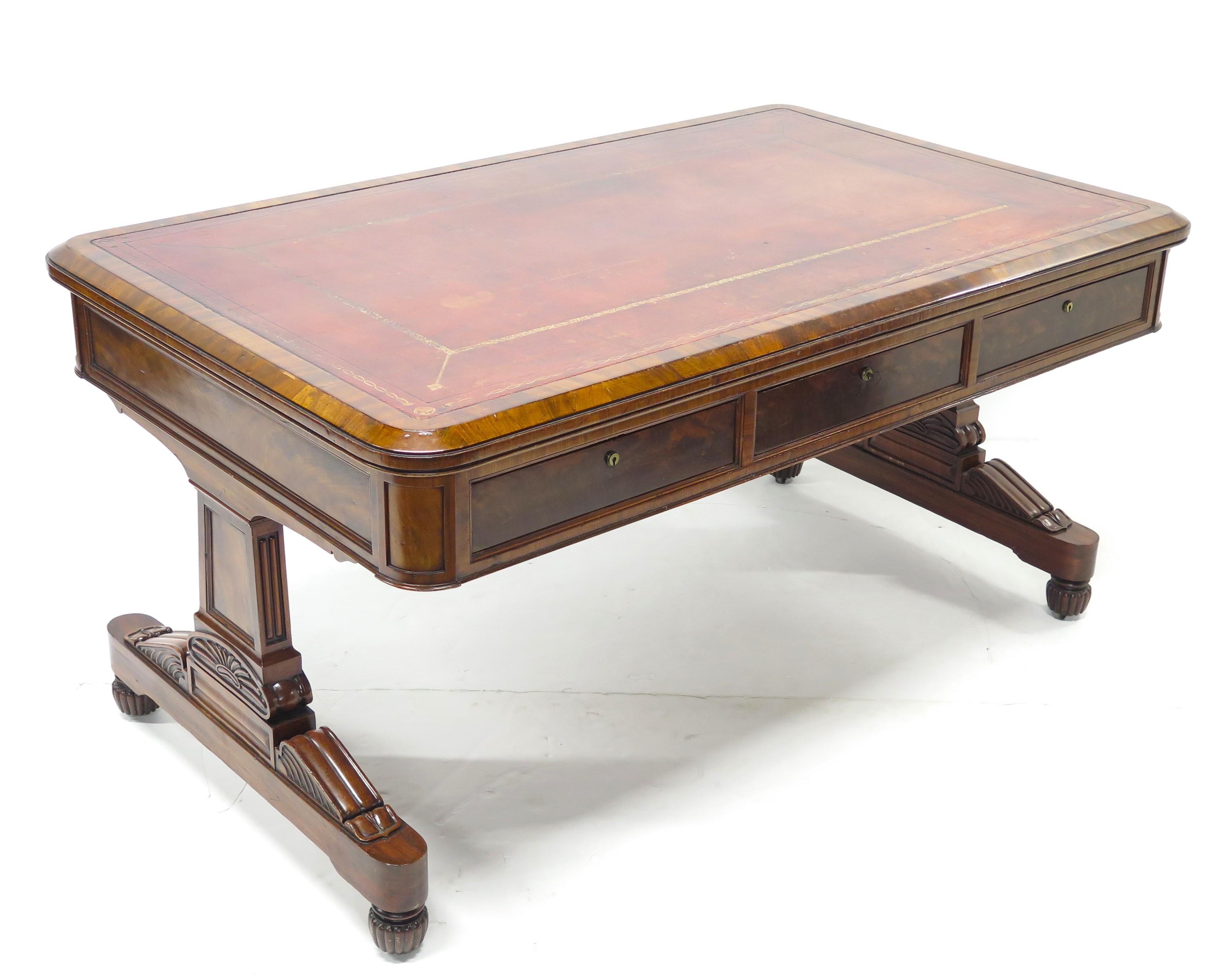 a William IV mahogany partners writing table / desk with gilt tooled faded red leather inset writing surface, paneled inset drawers and sides, trestle supports each side, England, circa 1830