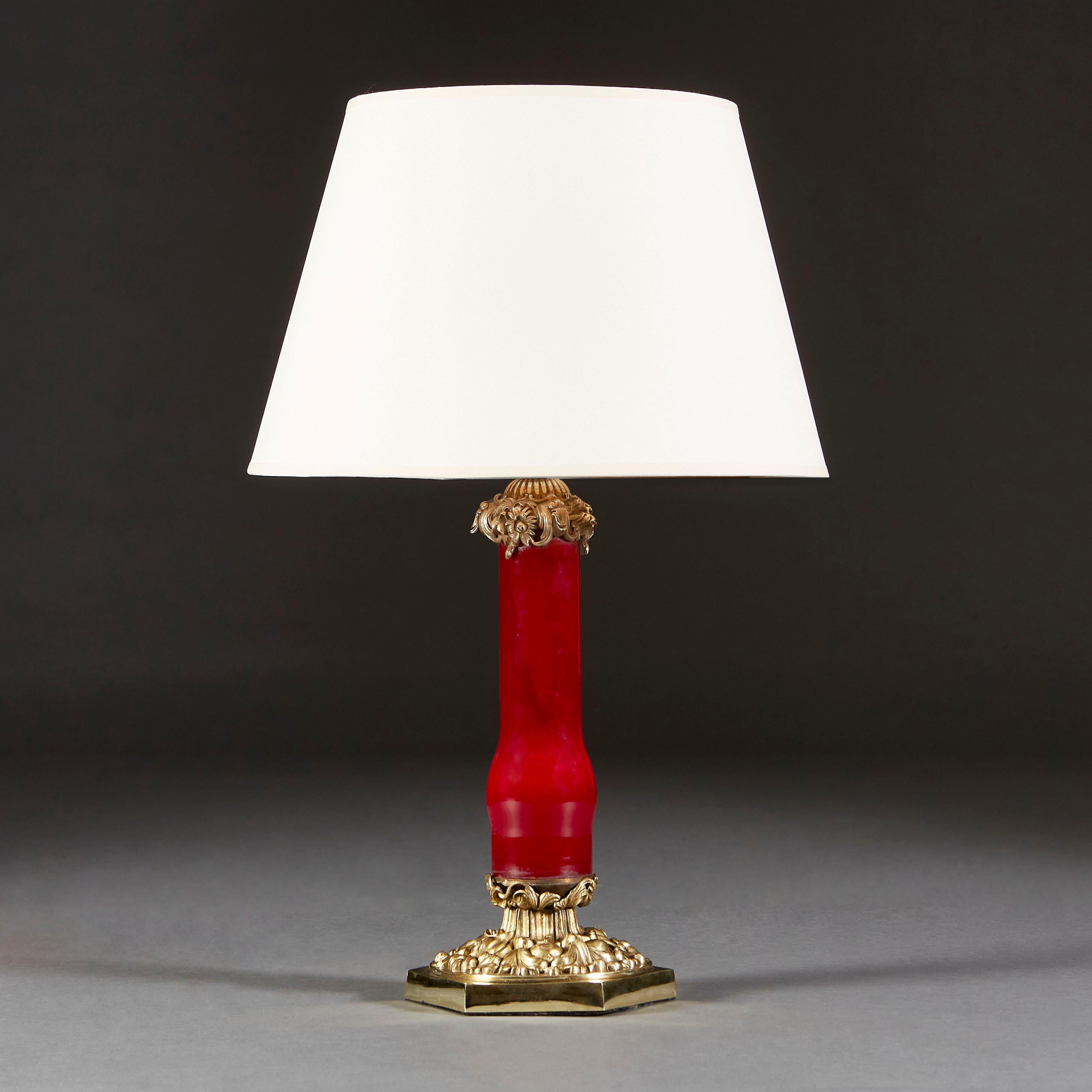 A mid nineteenth century red glass column lamp, with brass lead decoration to the top and to the base. All supported on a brass hexagonal base.

Currently wired for the UK.

Please note: Lampshade not included.
