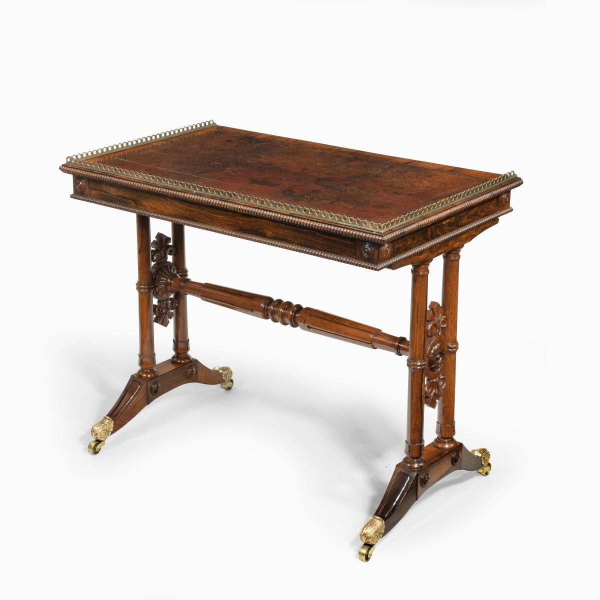 A William IV rosewood free-standing end support table attributed to Gillows, the rectangular top with the original leather and an ormolu gallery on three sides, all above a single disguised frieze drawer and supported on twin turned columns joined