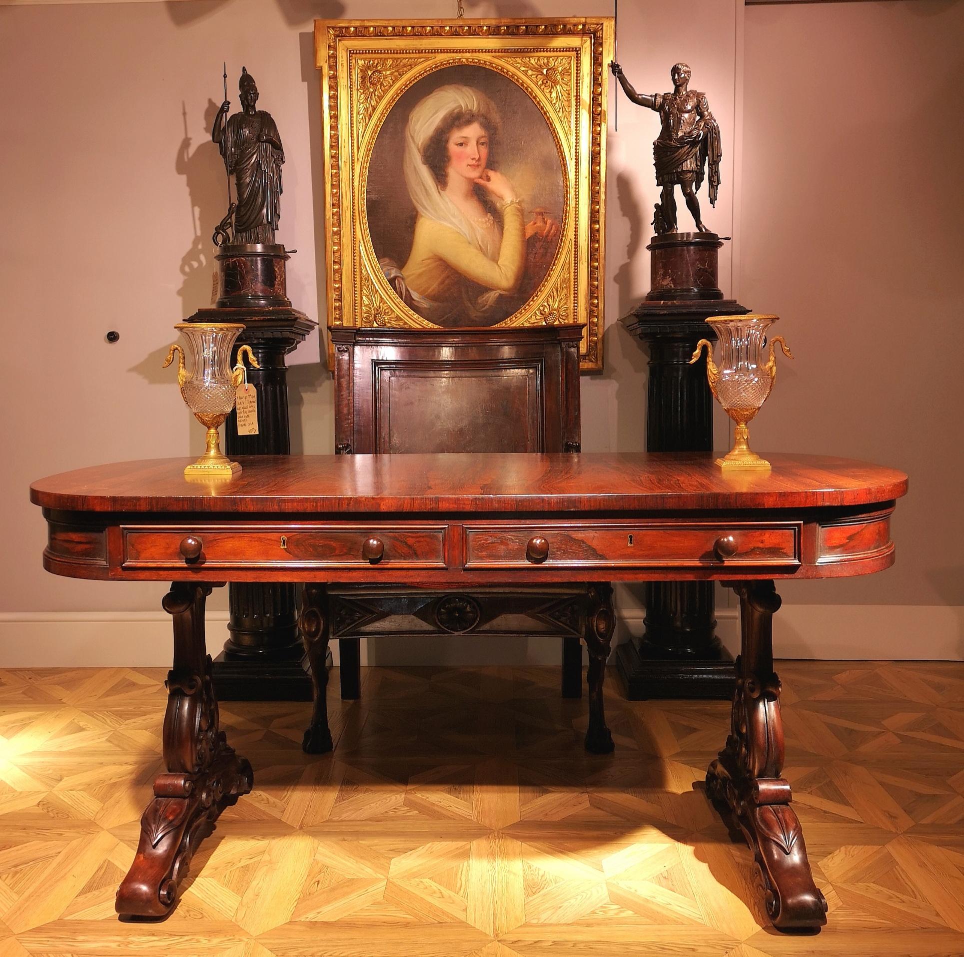 A William IV library or writing table made circa 1830 by the renowned Dublin firm of Williams & Gibton.  The table has a superbly grained and richly hued rosewood top set above two deep side drawers with turned and paired knobs, and blank drawer
