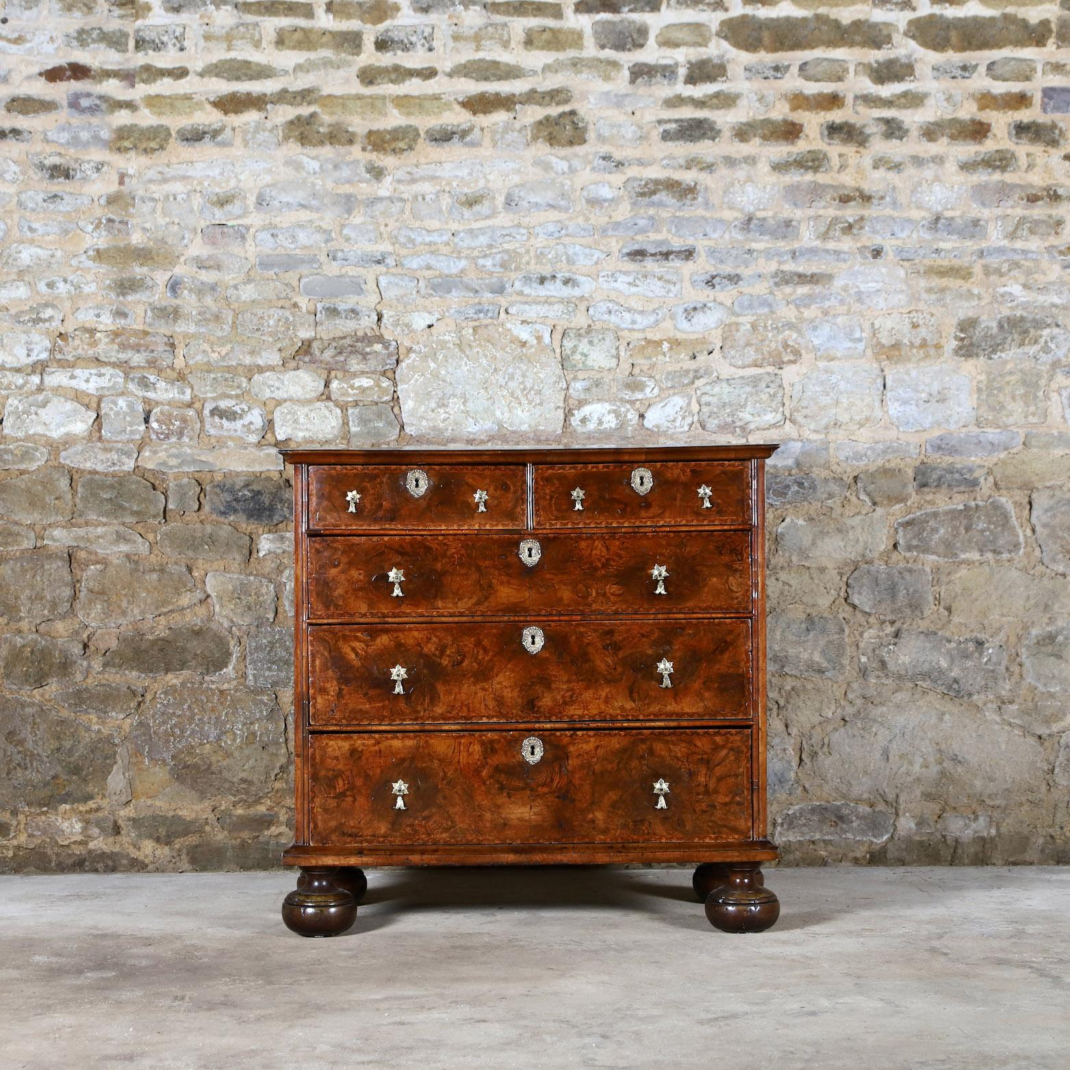 Vagabond Antiques presents an 18th Century walnut chest of drawers

England, Circa 1700 & later

”A classic William & Mary design, warm colour to the walnut veneer, inlaid with seaweed marquetry, raised on bun feet ”

