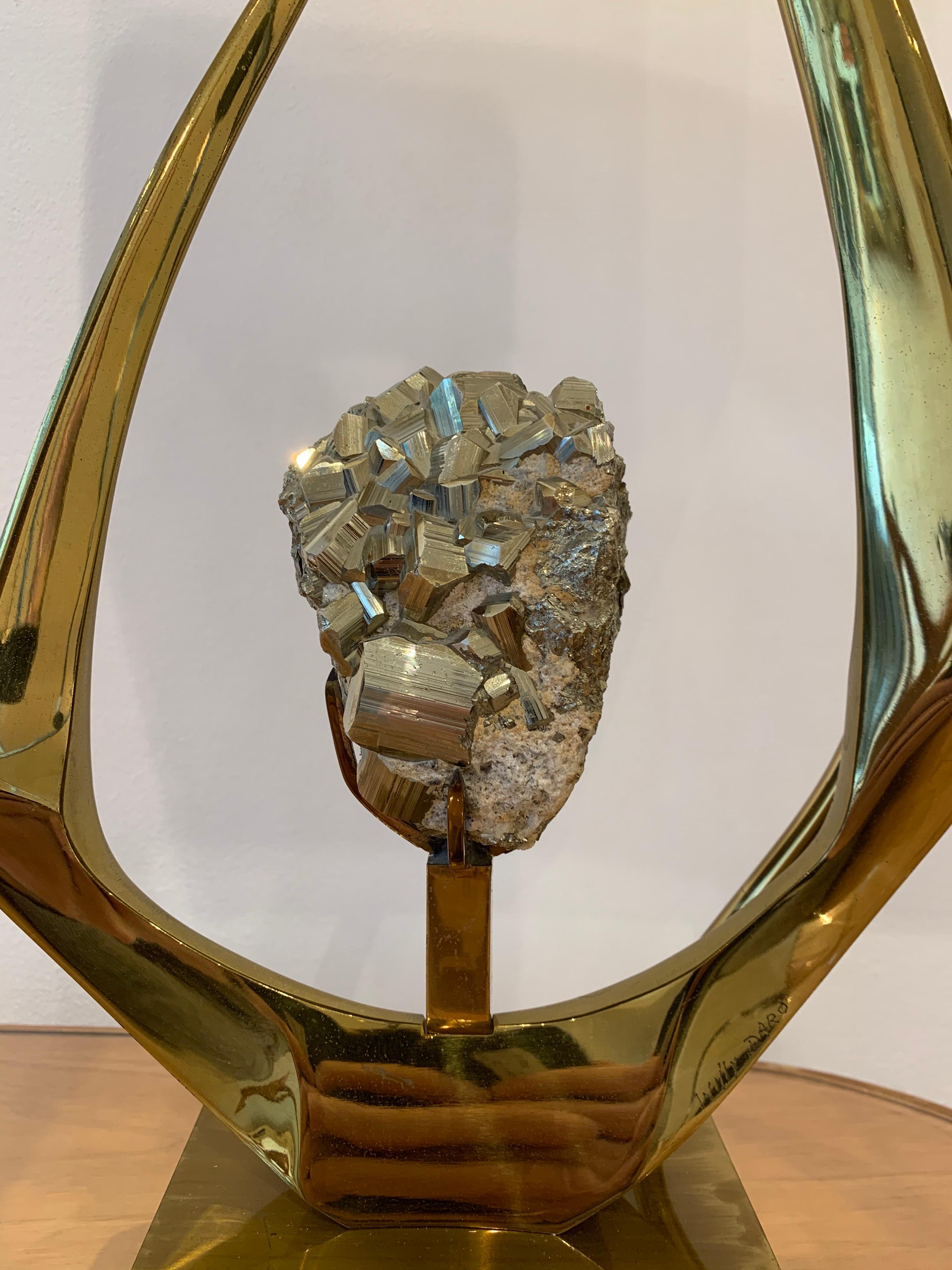 This brass lamp by Willy Daro is signed. It dates circa 1970s. The stone is a pyrite. Willy Daro specialised in mounting semi precious stone in a beautifully decorative brass lamp.