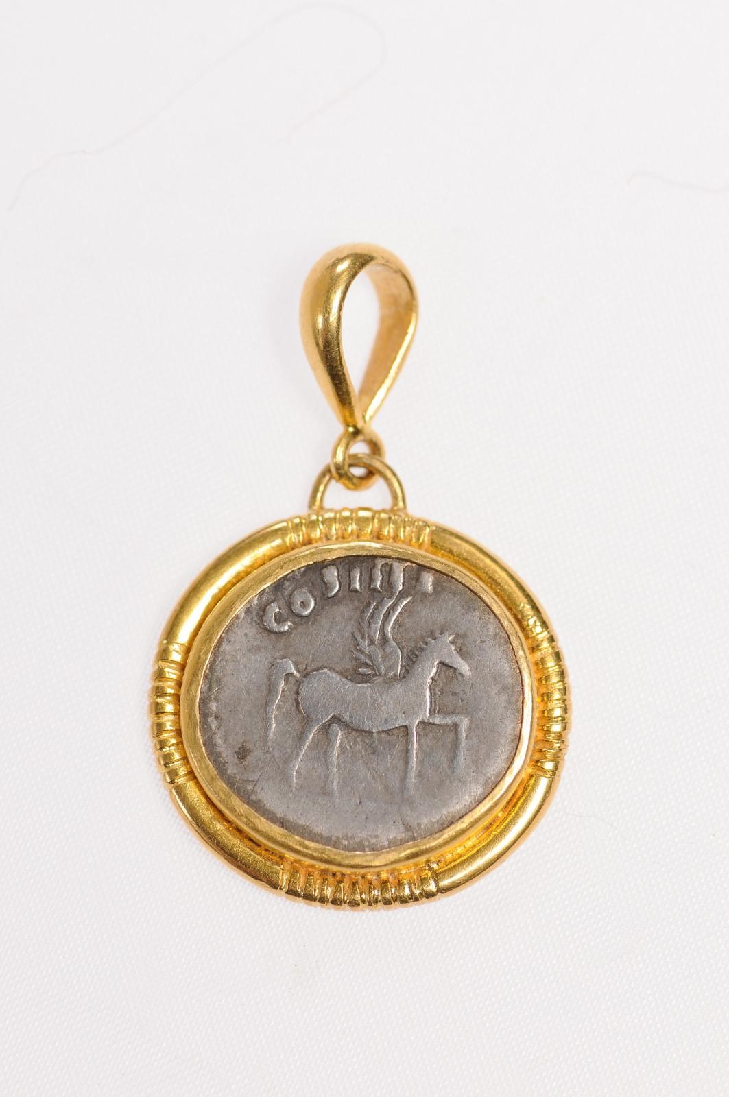 An Authentic Domitian, Silver Denarius Coin (Circa 76 AD), set in a custom 22k gold bezel with 22k gold bail. Pendant features a winged Pegasus, standing right with raised foot, with COS IIII above. Reverse side showing CAESAR AVG F DOMITIANVS,