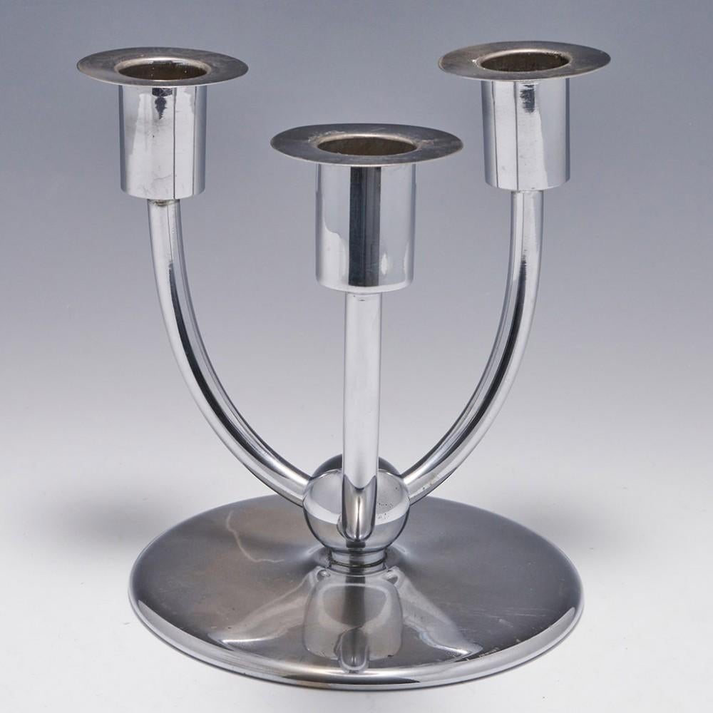 Heading : A WMF Candelabrum
Date : Marked WMF set within a dashed arch
Period : Weimar Republic
Origin : Geislingen, Germany
Decoration : Three upwardly curving arms mounted to a ball over a circular, shallow-domed base; single-piece capitals