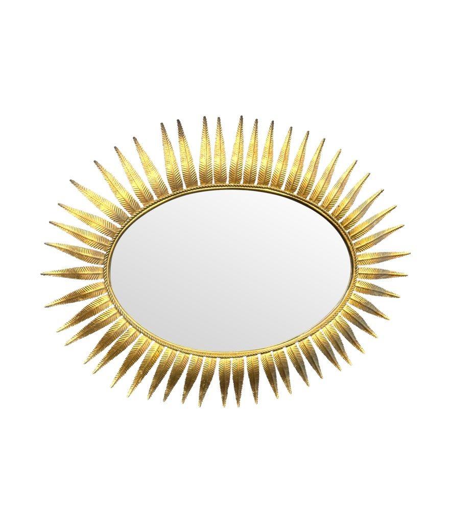 A wonderful large 1950s gilt metal oval Spanish sunburst, eyelash mirror gilt metal stylised leaves around the metal rope frame.  It can be hung landscape or portrait. 