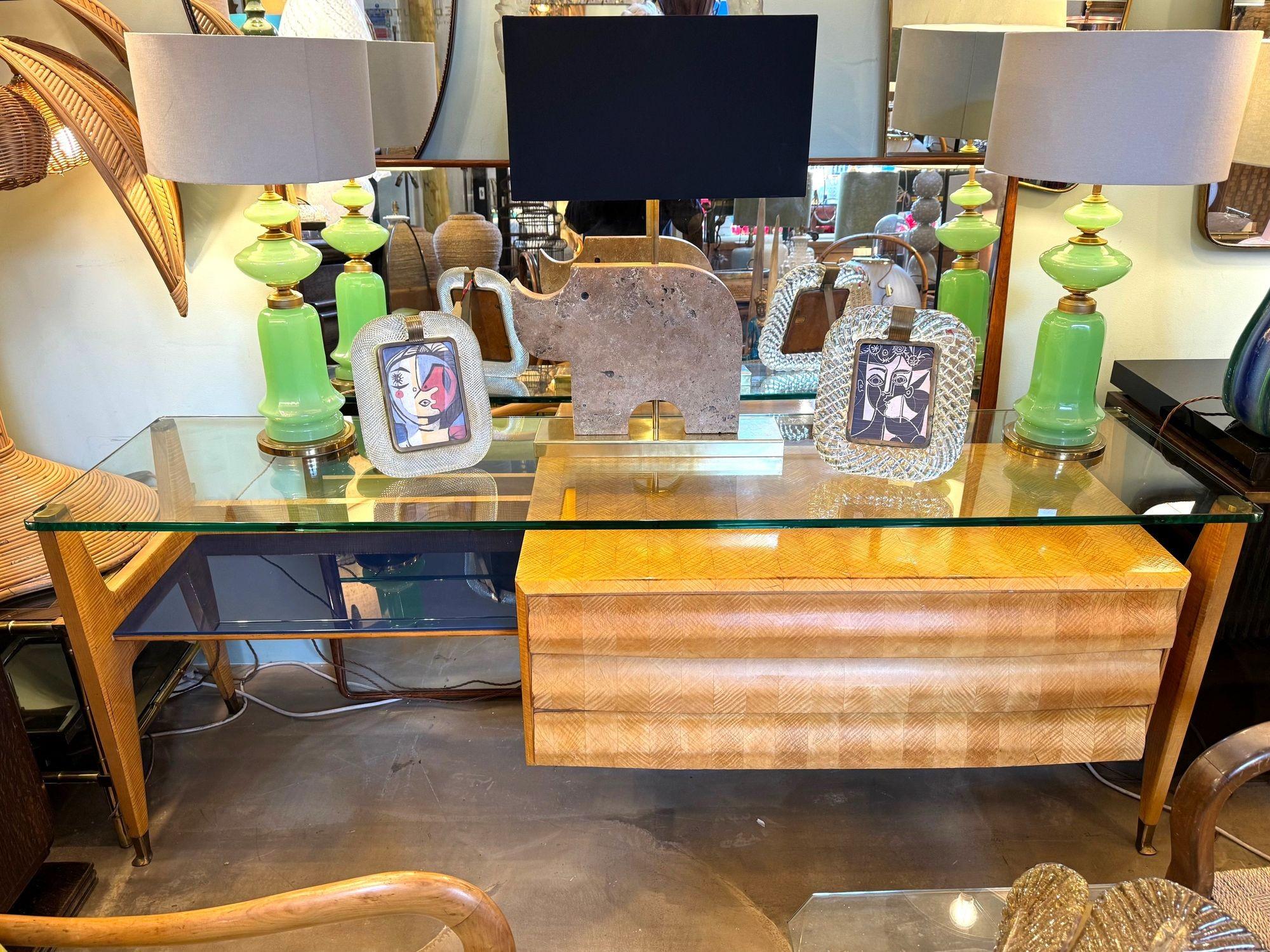 A wonderful 1950s three drawer console dresser desk by Vittorio Dassi. Beautifully designed in lacquered herringbone, birdseye maple wood. The thick 15mm glass top is supported by heavy solid brass top mounts. Underneath there are blue glass panels