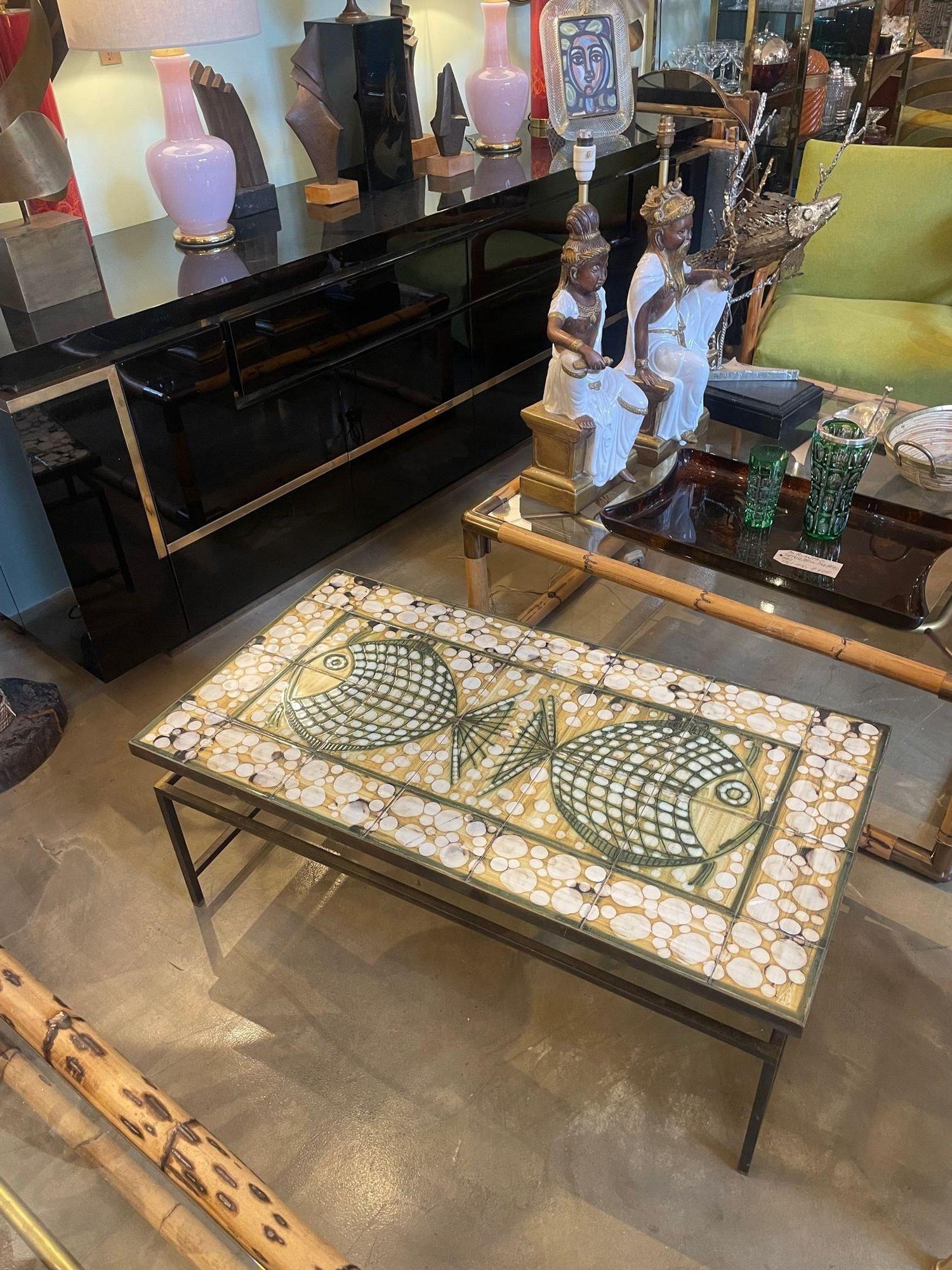 A wonderful 1960s ceramic tiled coffee table by Dennis Townsend, made up of 28 unique tiles that create a wonderful underwater fish design, mounted on a gilt metal base with floating top design. Signed in the lower right hand corner tile with Iden