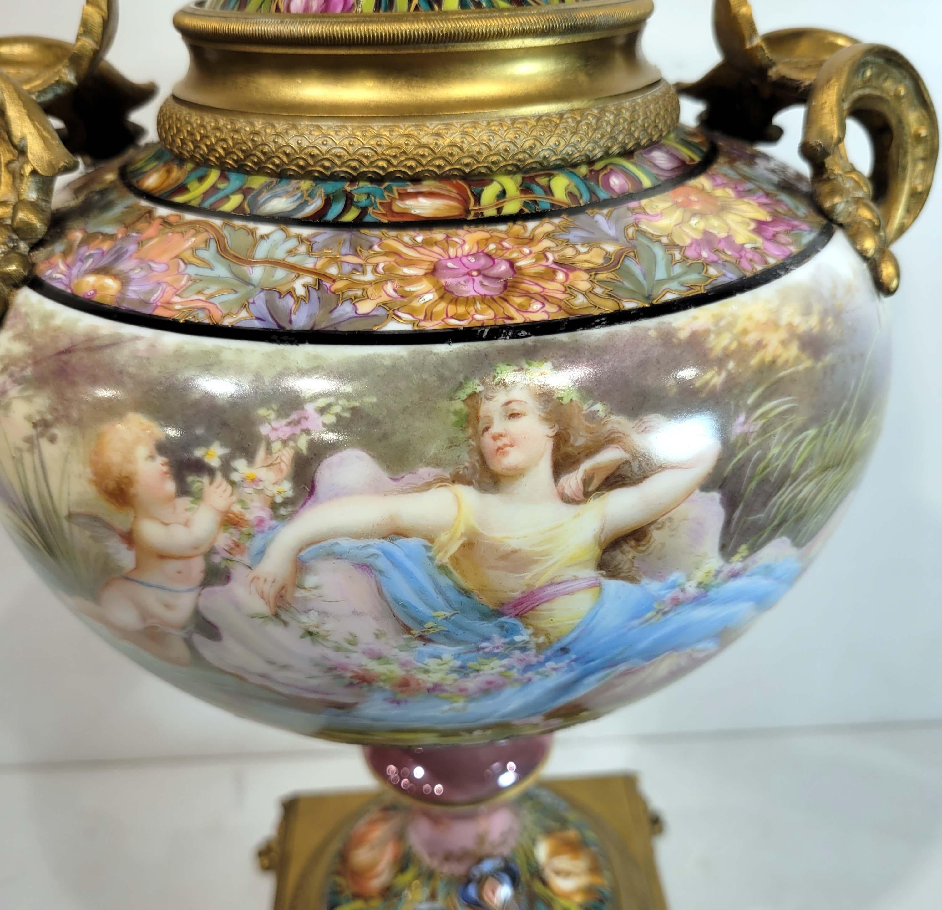 A Wonderful Art Nouveau Sevres Poecelain Covered vase. Circa 1890-1910 French art nouveau hand painted and ormolu mounted Sevres porcelain vase, depicting a maiden in a garden setting with a cherub decorating her with wild flowers while she has her