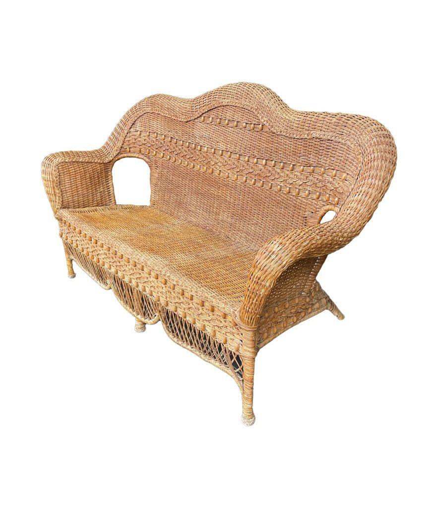 A wonderful curvaceous 1960s woven wicker and wood three seater sofa with, beaded detail on the back and front