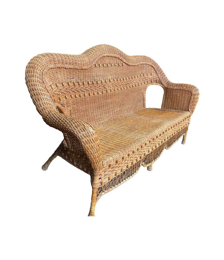 French A wonderful curvaceous 1960s woven wicker and wood sofa with beaded detail For Sale