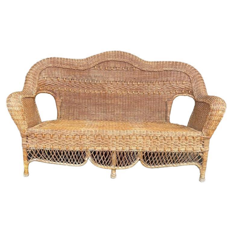 A wonderful curvaceous 1960s woven wicker and wood sofa with beaded detail For Sale