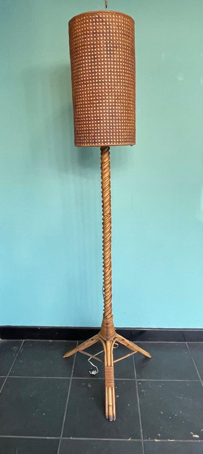 A wonderful French 1960s bamboo floor lamp by Louis Sognot with coiled bamboo stem and original rattan and parchment shade. Re wired with antique cord flex and PAT tested