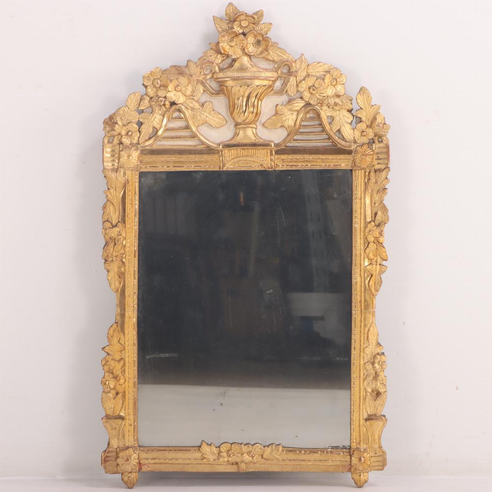 Splendido specchio francese Luigi XV, C 1800, con un'urna centrale di fiori affiancata da altre fioriture a cascata sulla cresta, il tutto intagliato nel legno. La cornice conserva una superba finitura dorata con uno sfondo di vernice color crema