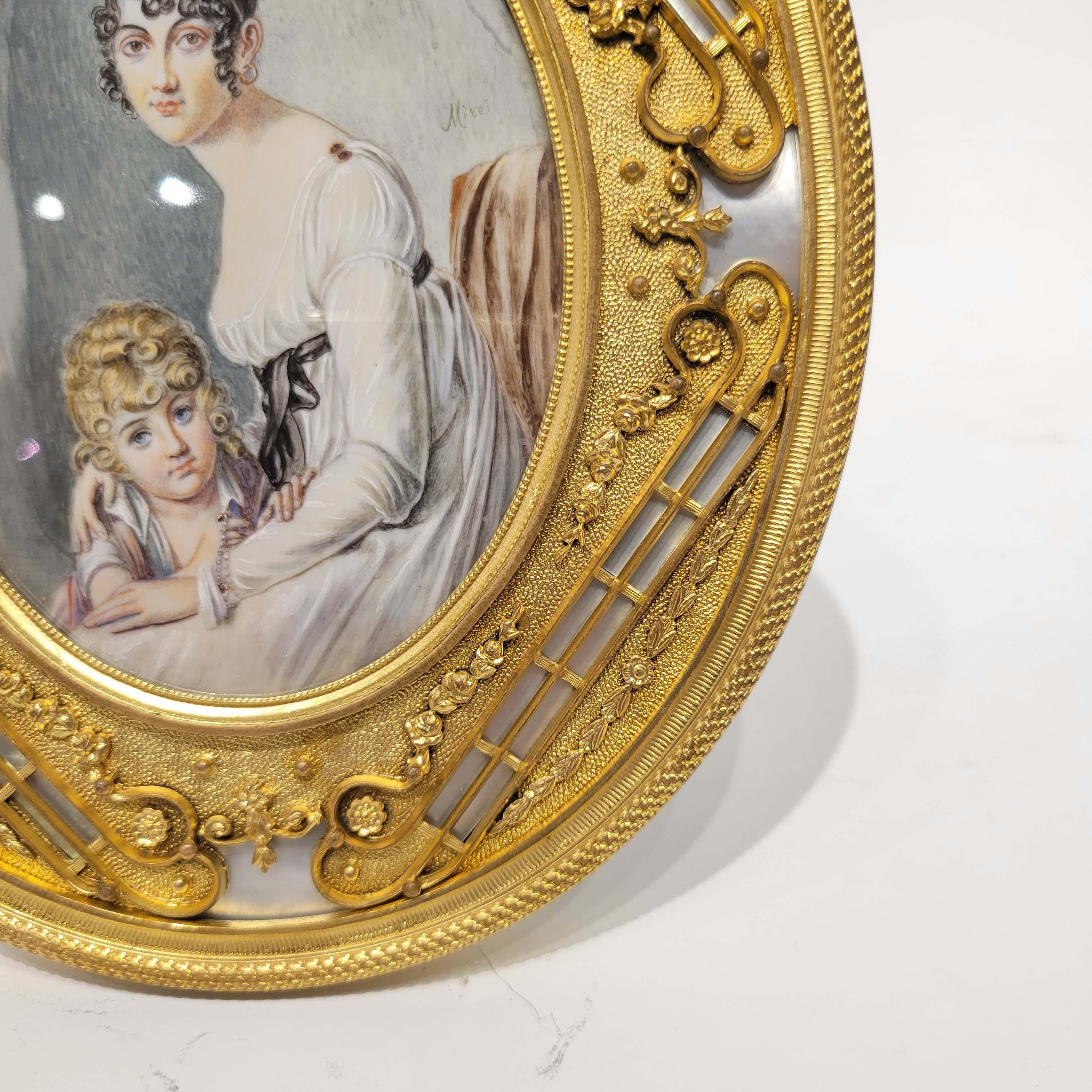 A magnificent signed antique hand painted miniature painting of mother and child in a wonderful gilt bronze frame inlayed with mother of pearl plaques. France, circa late 19th century.