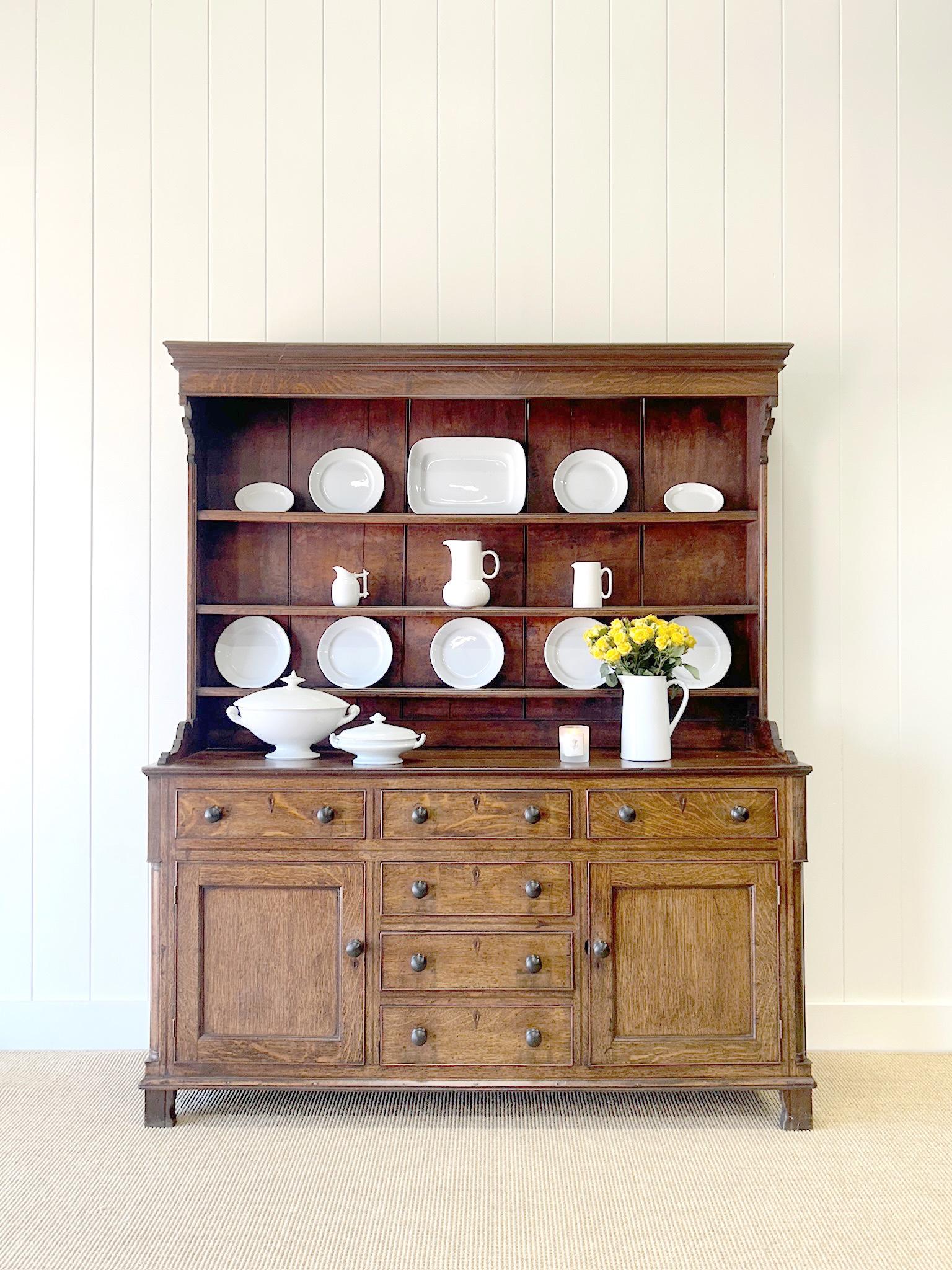 A large oak Welsh dresser or cupboard.  Lower portion with 6 drawers and 2 doors.  Upper plate rack with decorative corners. A truly beautiful piece. Dovetail drawer construction.  Charming columns work their way down the sides of the base. Wooden
