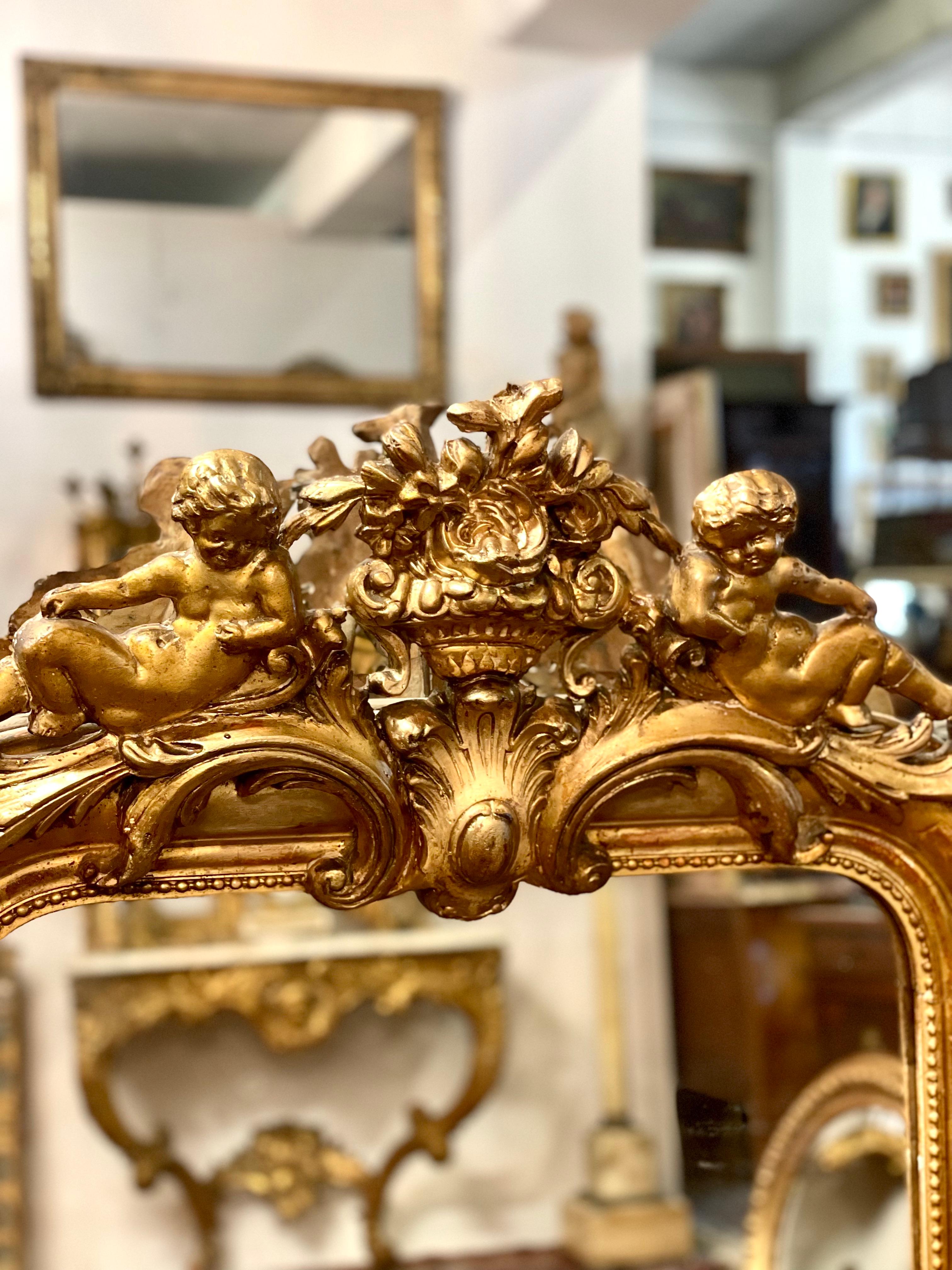 A wonderful Louis Philippe giltwood mirror, dating from the later part of the 19th century, with the signature rounded upper corners and elegant frame so reminiscent of the period. This imposing wall mirror is surmounted by an ornate crest,