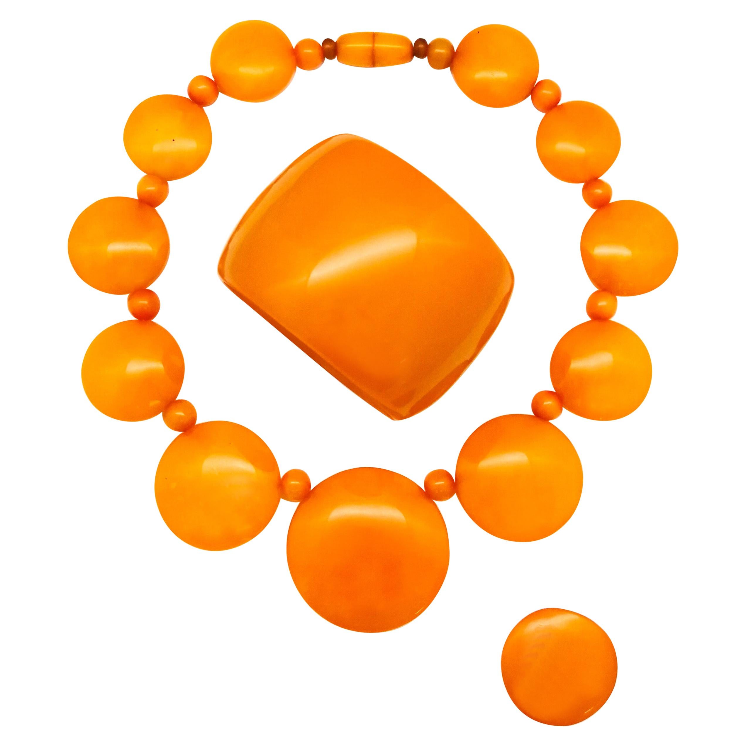A wonderful orange Bakelite necklace, bangle and ring combination, 1930s
