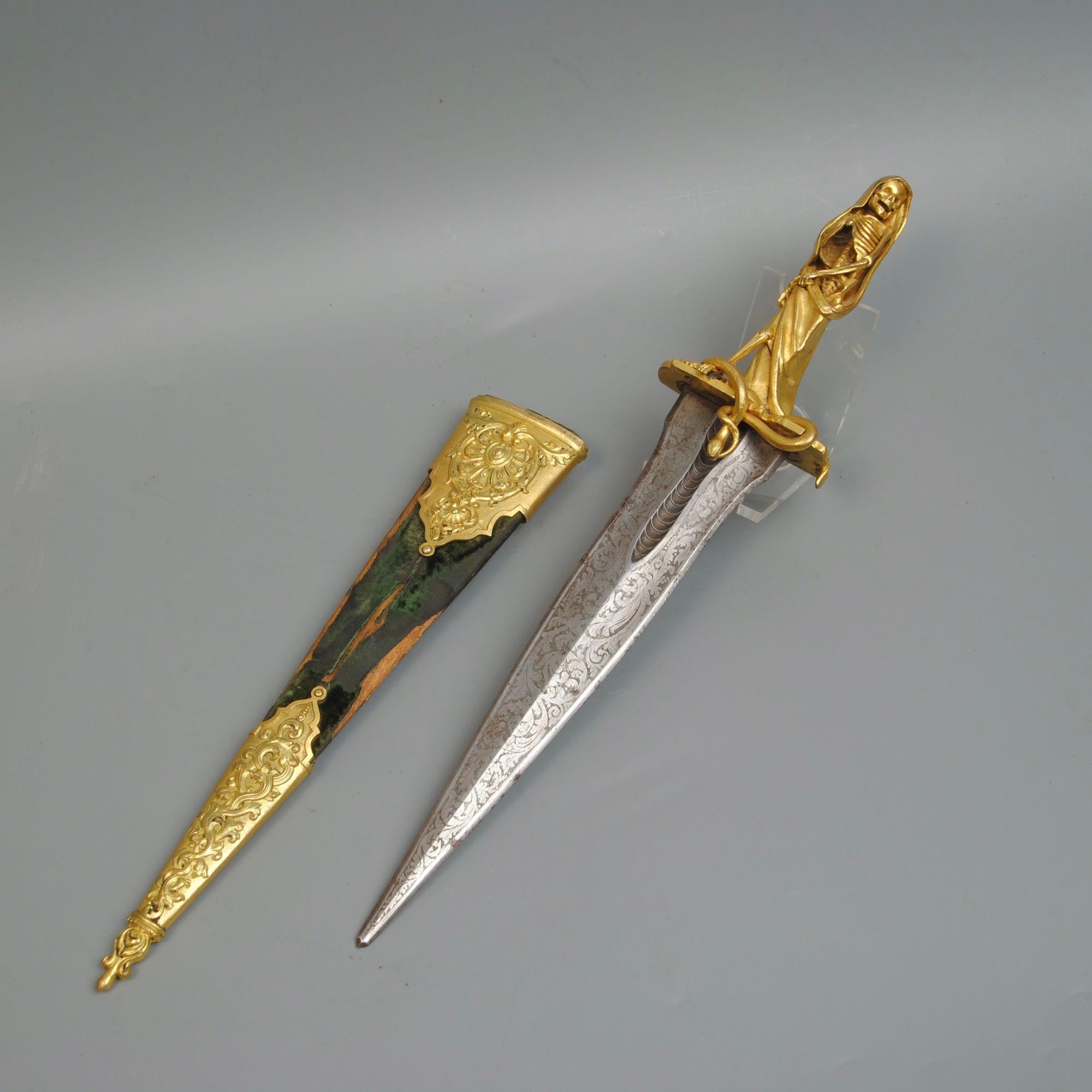 Un pugnale rituale francese della metà del XIX secolo con una superba figura di padre scheletrico della morte, la lama incisa e il fodero montato in ormolu e fatto sembrare molto più antico.
Circa 1840.
Un esemplare simile è stato venduto a Bonhams