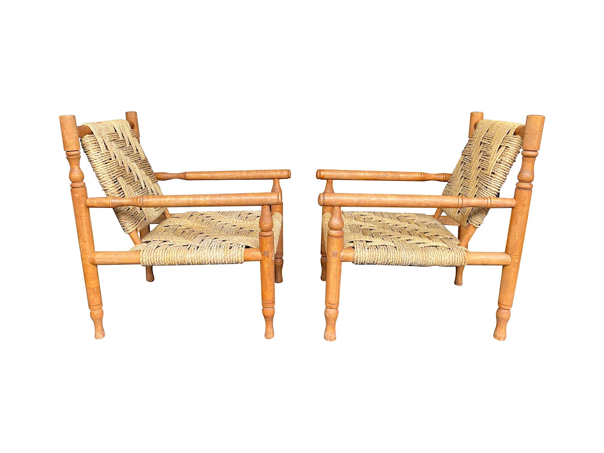 A wonderful pair of 1950s armchairs by Adrian Audoux and Frida Minet with primitive style hand turned beech wood frames and orignal handwoven abaca rope seats and backs, all in perfect original condition. These beautifully designed iconic chairs are