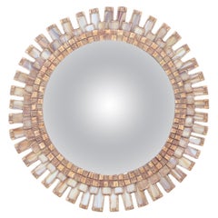 Un espejo convexo de madera y resina con un borde geométrico de cristal color marfil