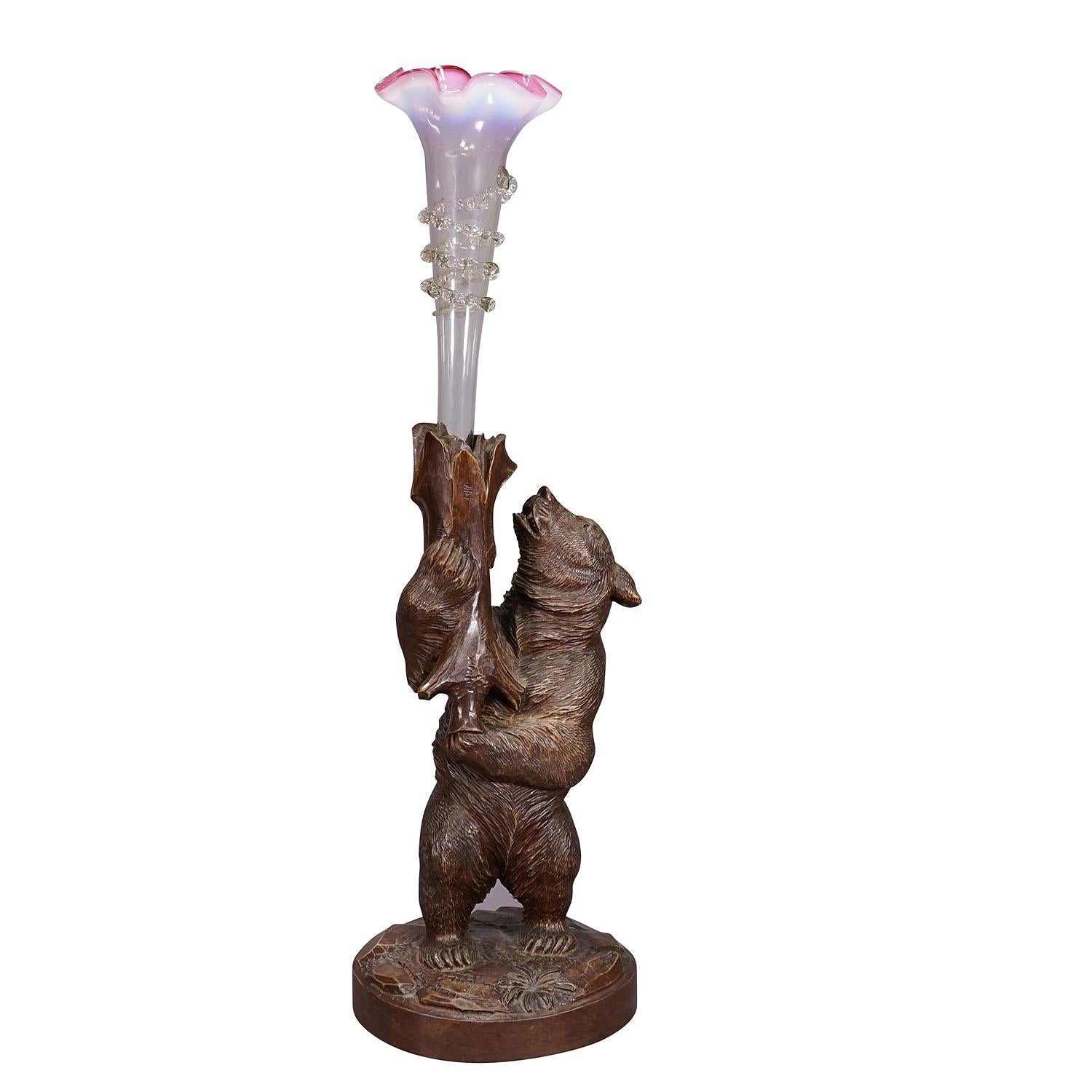 A Wooden Carved Black Forest Bear with Glass Vase ca. 1900s

A finely carved standing Black Forest bear holding an Art Nouveau glass vase in his hands. Executed in Brienz, Switzerland, around 1900. Very good condition. Height of the bear: 14.2'