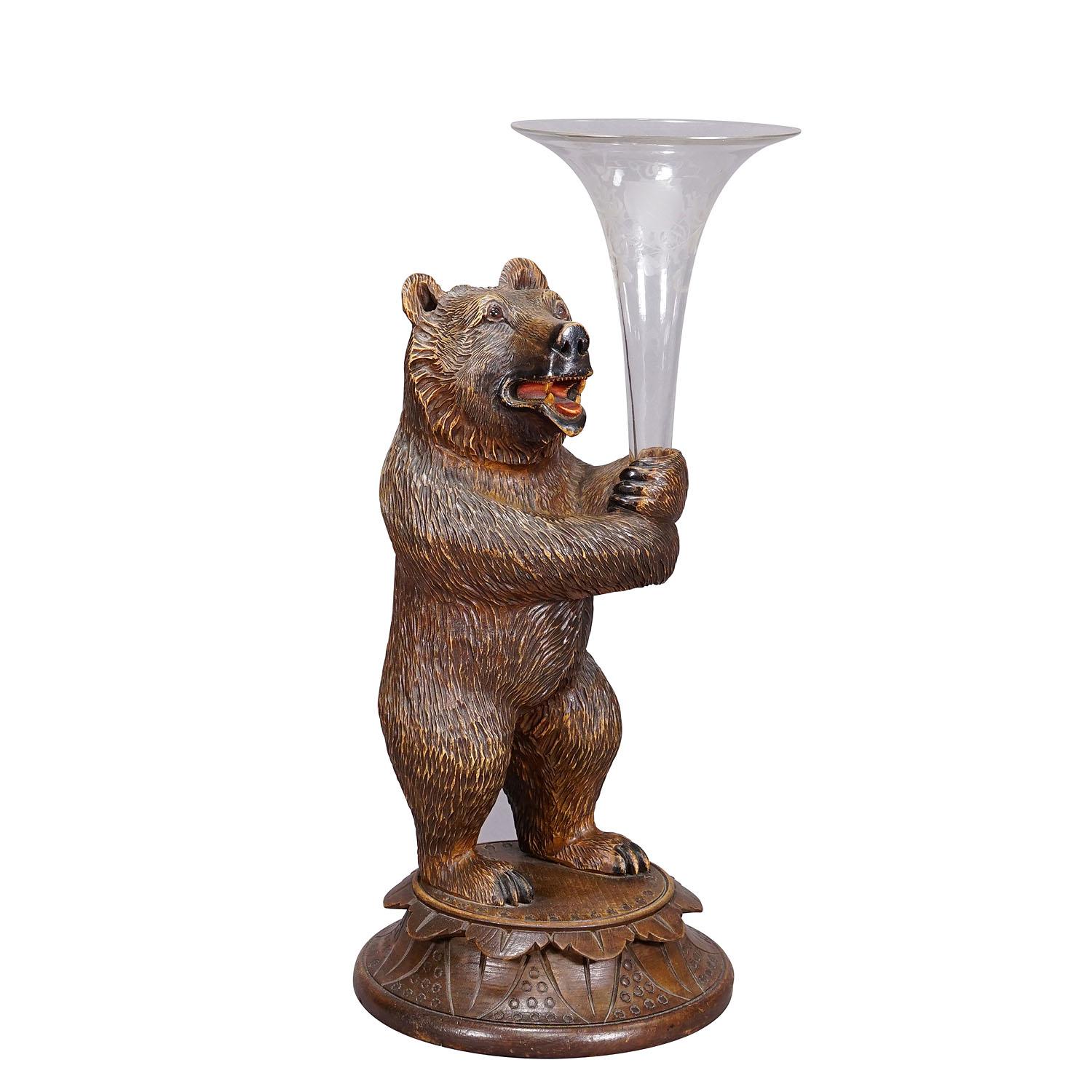 A Wooden Carved Black Forest Bear with Glass Vase
Item e7275
A nicely carved Black Forest bear holding a glass vase in its hands. Executed in Brienz, Switzerland around 1920. Very good condition. Heigt of the bear: 11.8' inches (30 cm). A great
