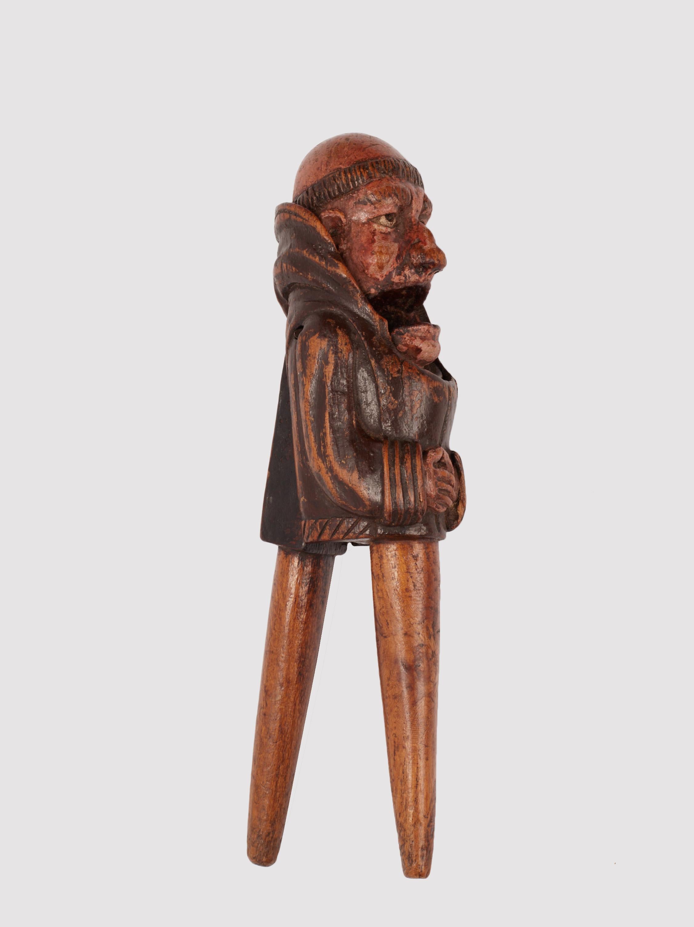 Schiaccianoci in legno di nocciolo intagliato. I manici sono a forma di fuso a connettersi alla parte superiore. La sculpture représente le buste d'un monaco avec du tonaca et du cappuccio. Les mains en position d'attente. La lame postérieure, la